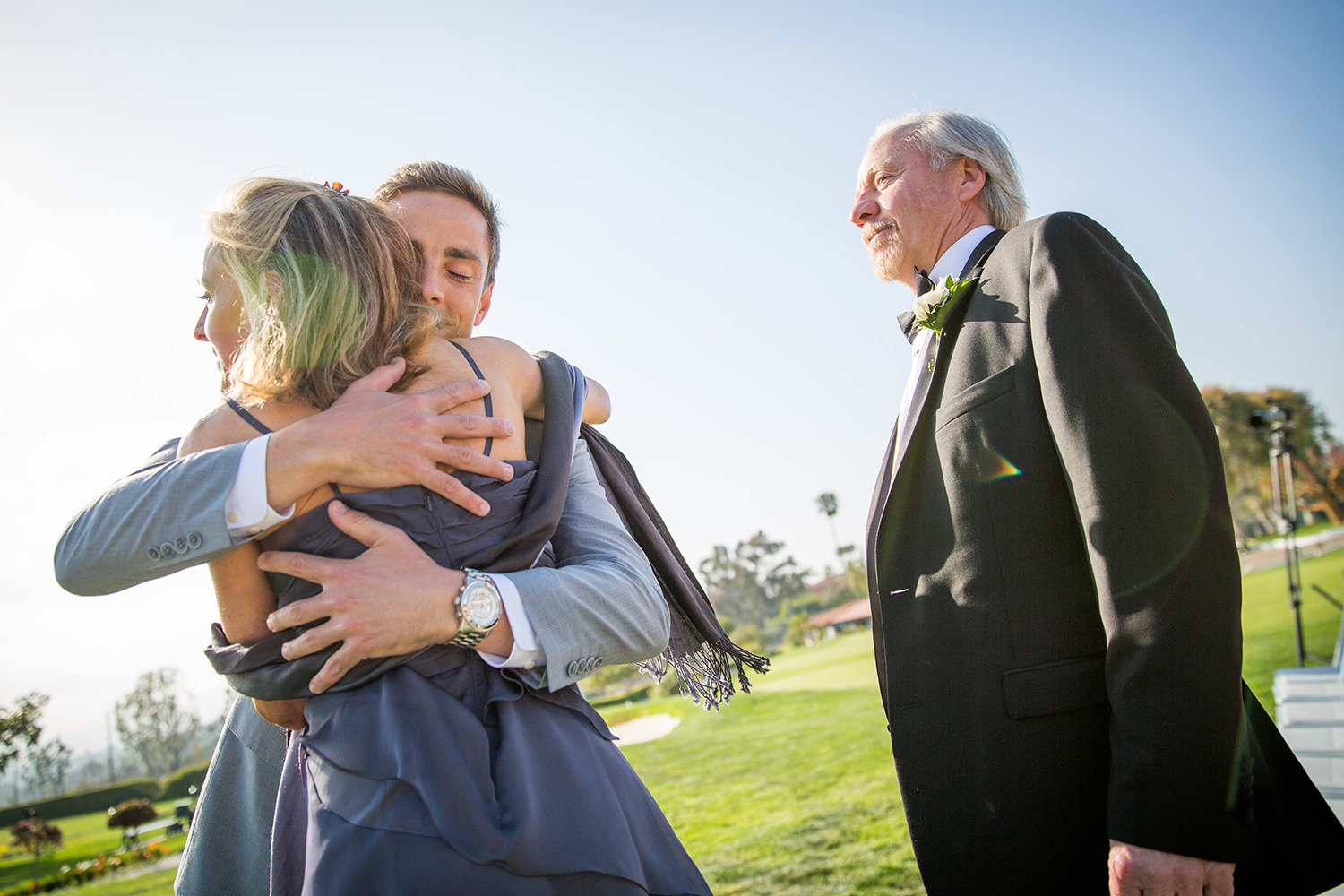 groom hugging parents at ceremony