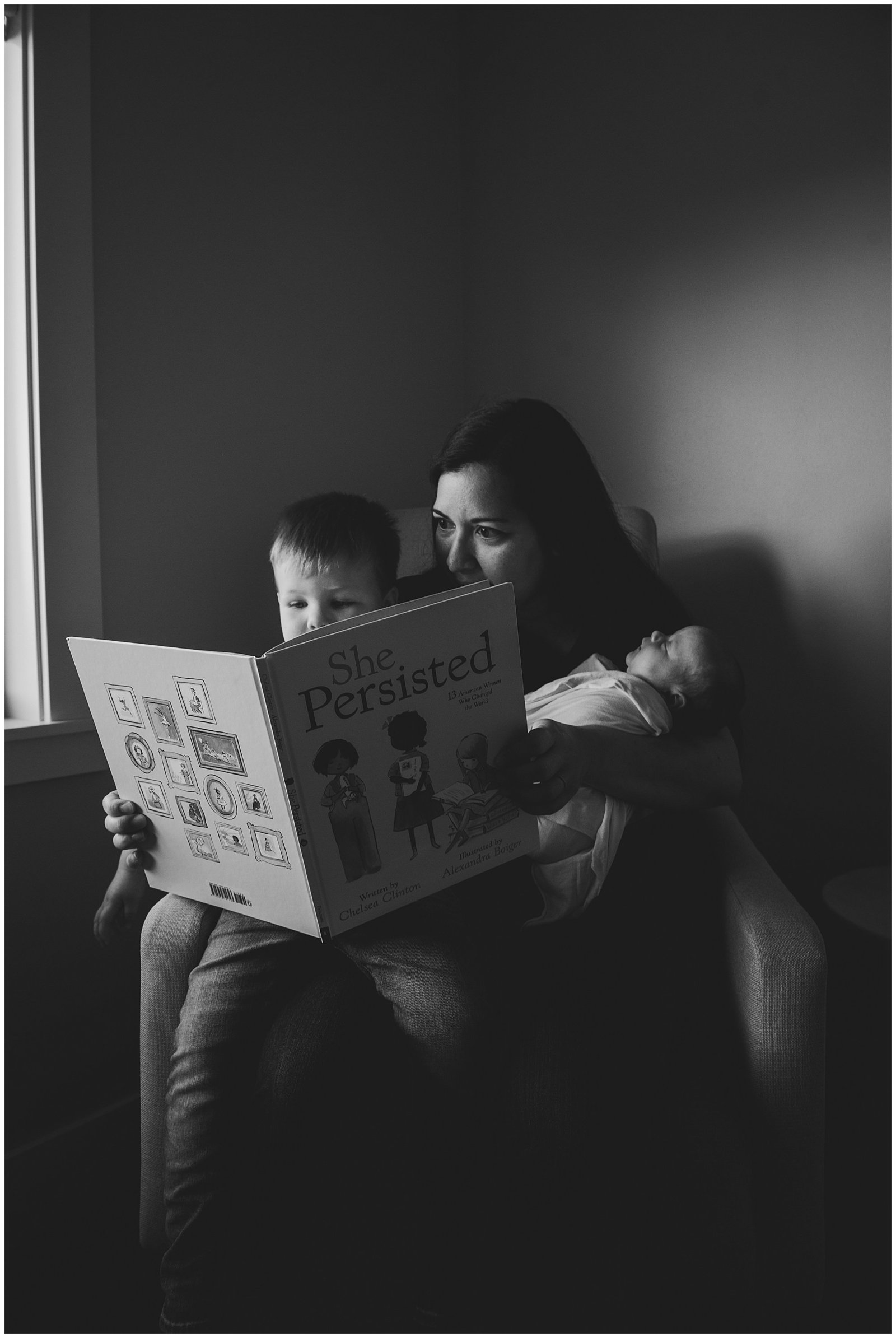mom reading to newborn baby girl and big brother