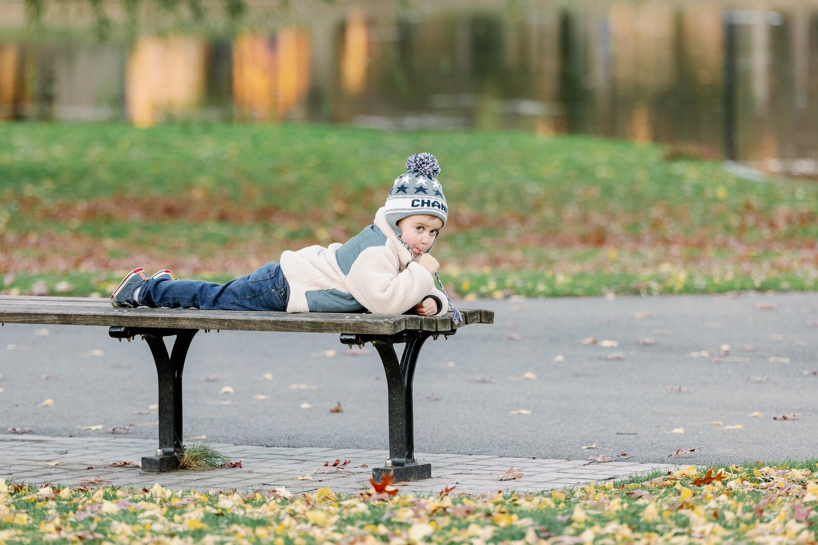 boy on bench in hat with lollipop