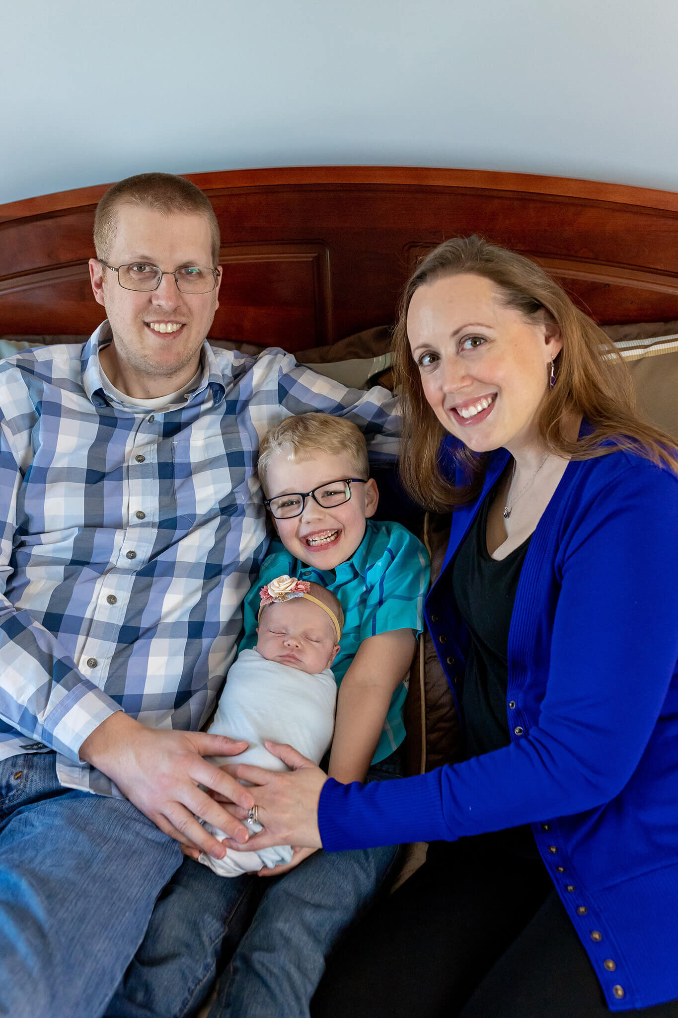 A family of four snuggled in bed in their Manassas home.