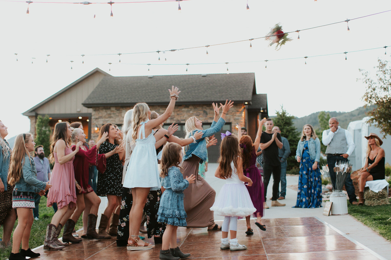 bride throwing her bouquet to sea of women at her Loveland Colorado wedding