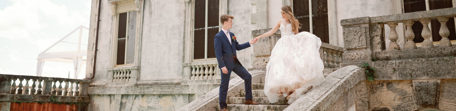 A young married couple walking down the steps of a historical mansion in South Florida.