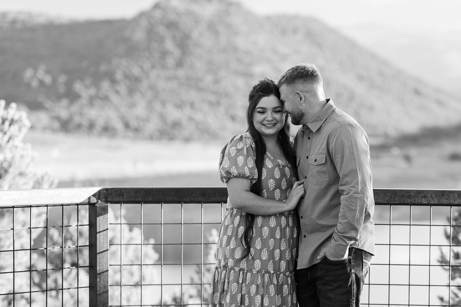 Mountains, and lake in background of couple smiling