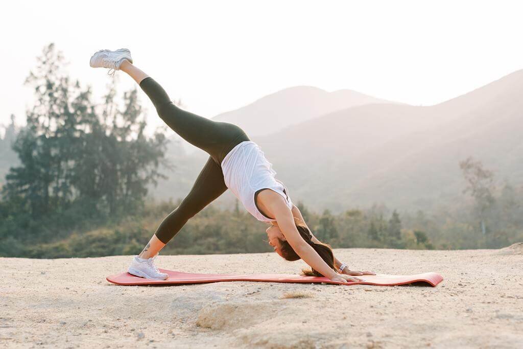 Women doing yoga poses outdoor in the mountains for her branding photoshoot.