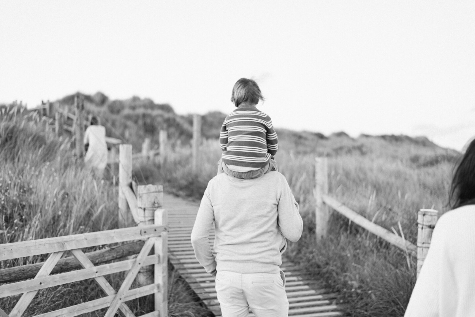 a little boy on dads shoulders at a family photoshoot in Billingshurst
