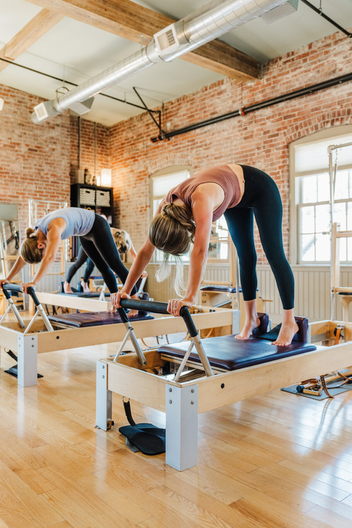 woman works on pilates reformer in a boston studio