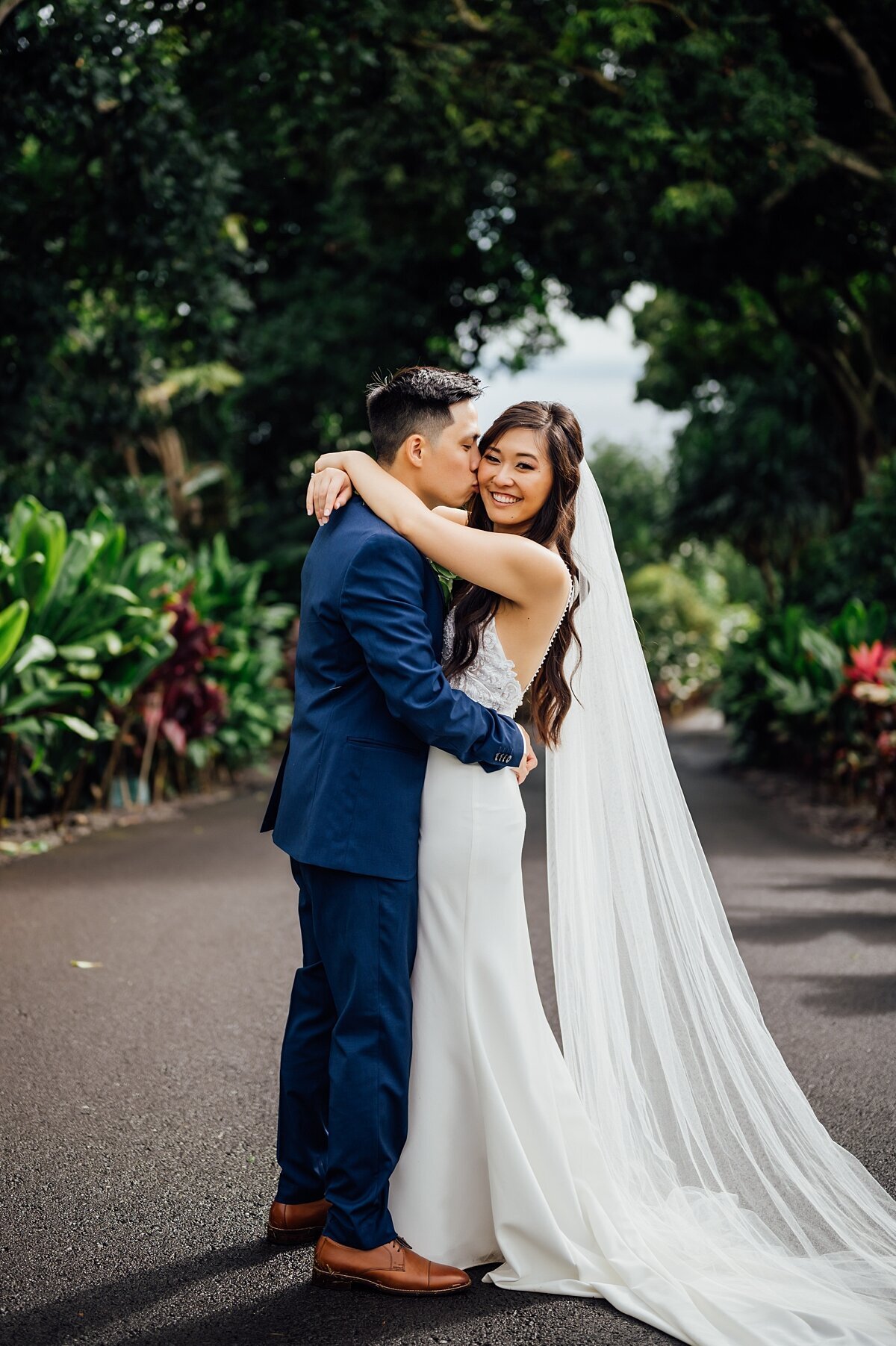 groom kisses bride on the cheek at their wedding on the big island