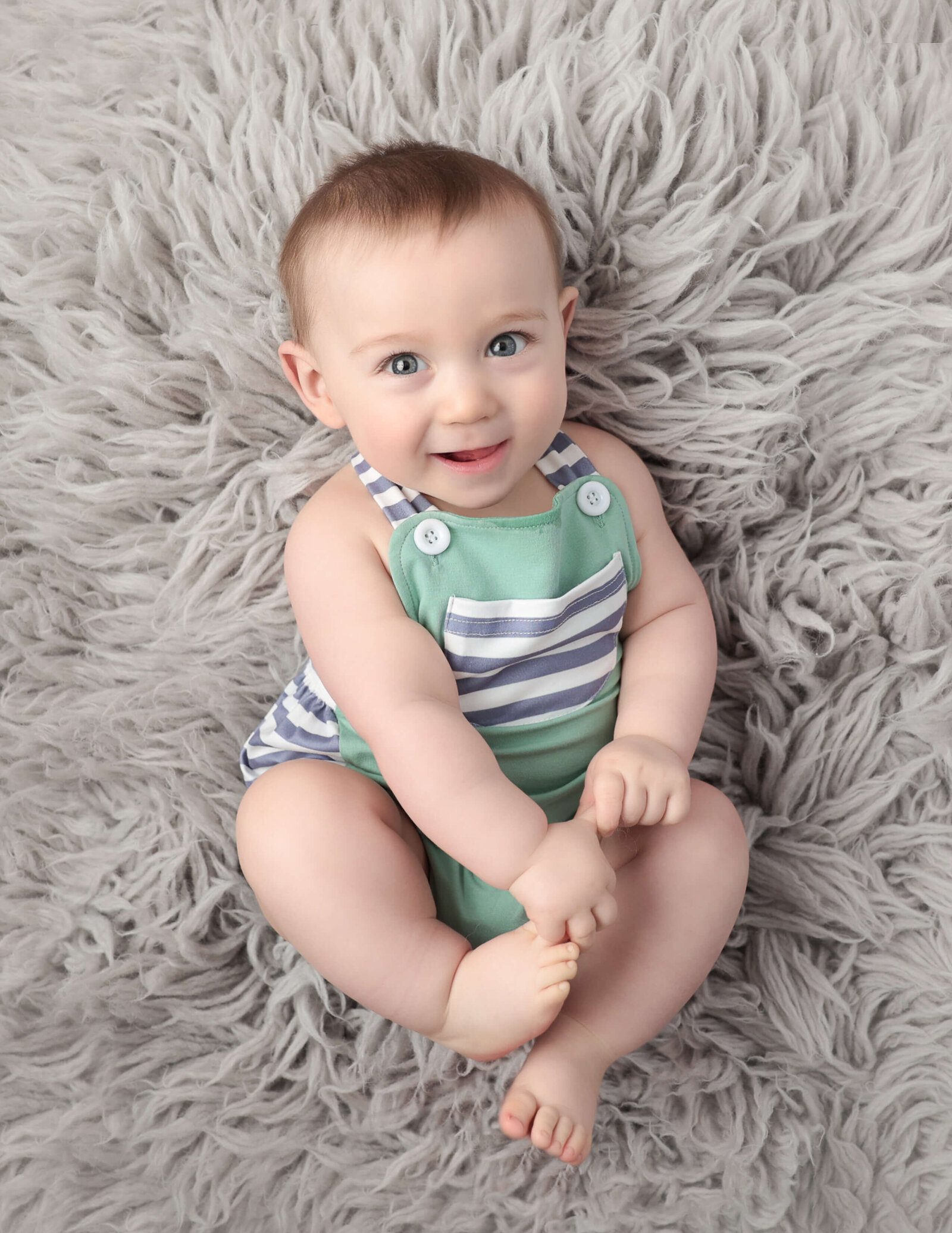 Smiling 6 month old laying on his back, Rochester, Ny studio.