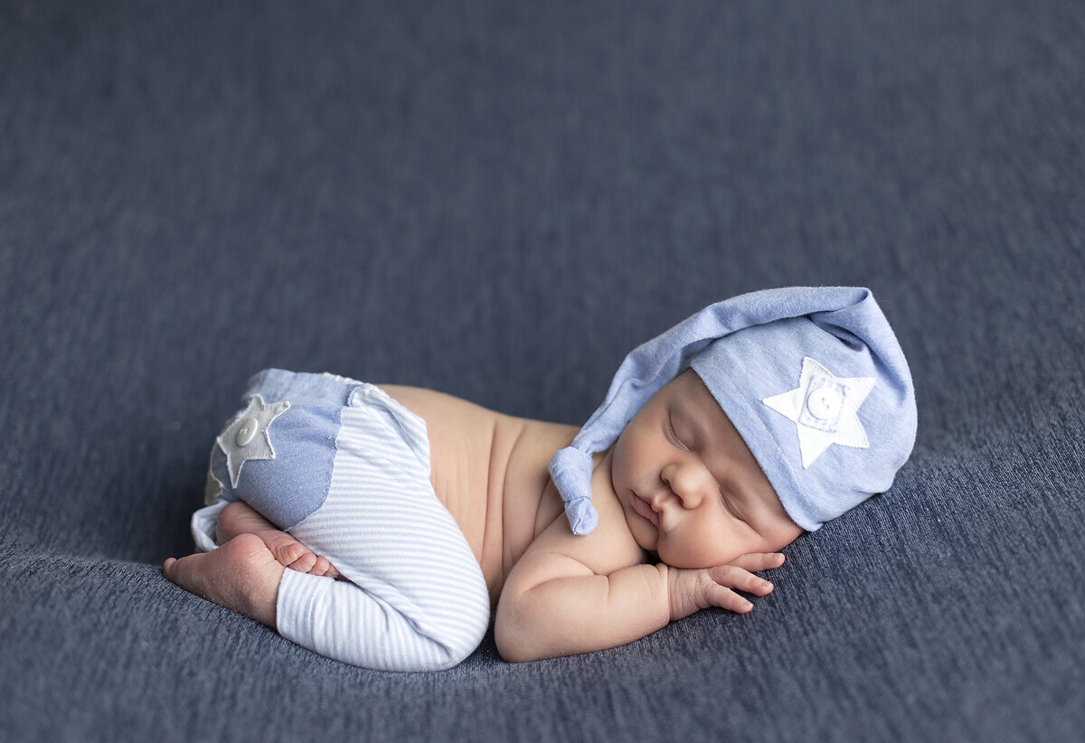 Newborn boy curled up at his Dallas newborn photoshoot.