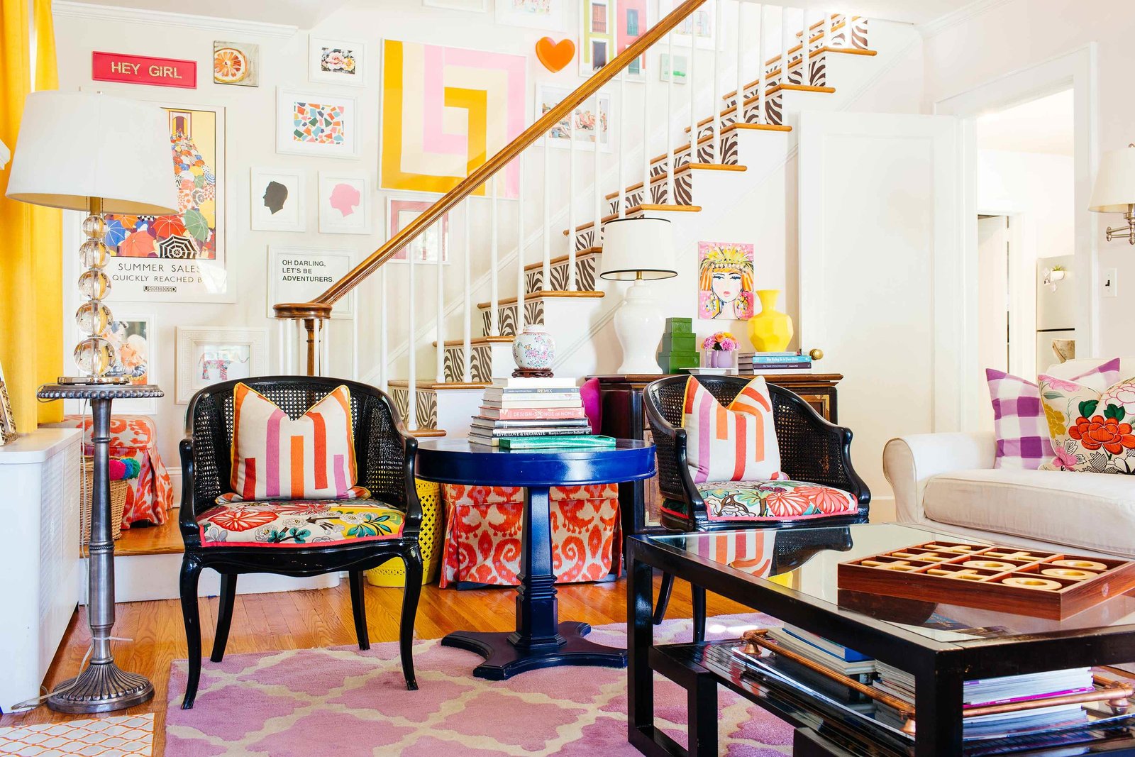 A colorfully decorated living room with a staircase backdrop.
