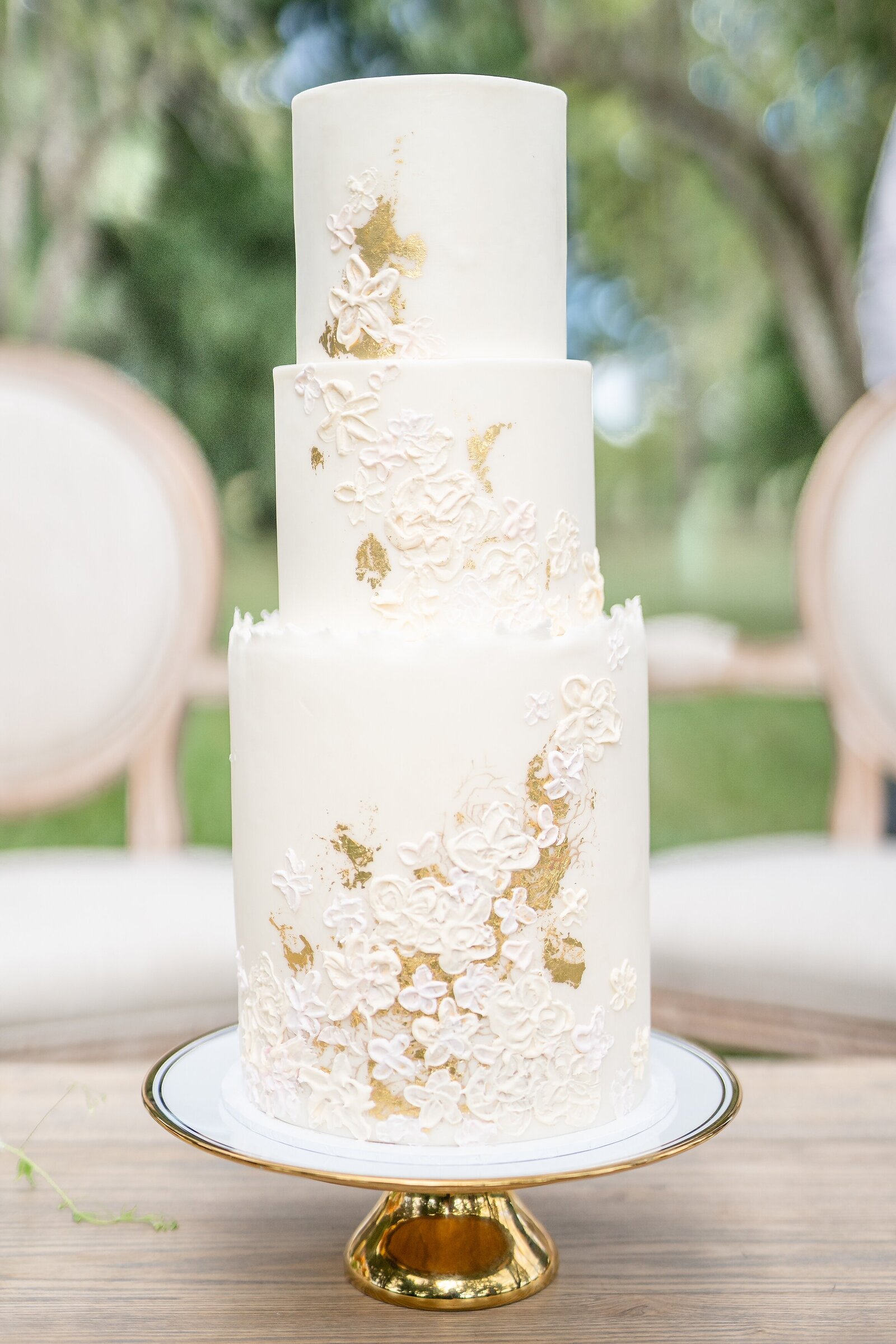 Amalfi-coast-inspired-micro-wedding-3-tier-wedding-cake-with-stunning-gold-cake-stand-and-gold-and-white-floral-decorations-by-The-Dessert-Room