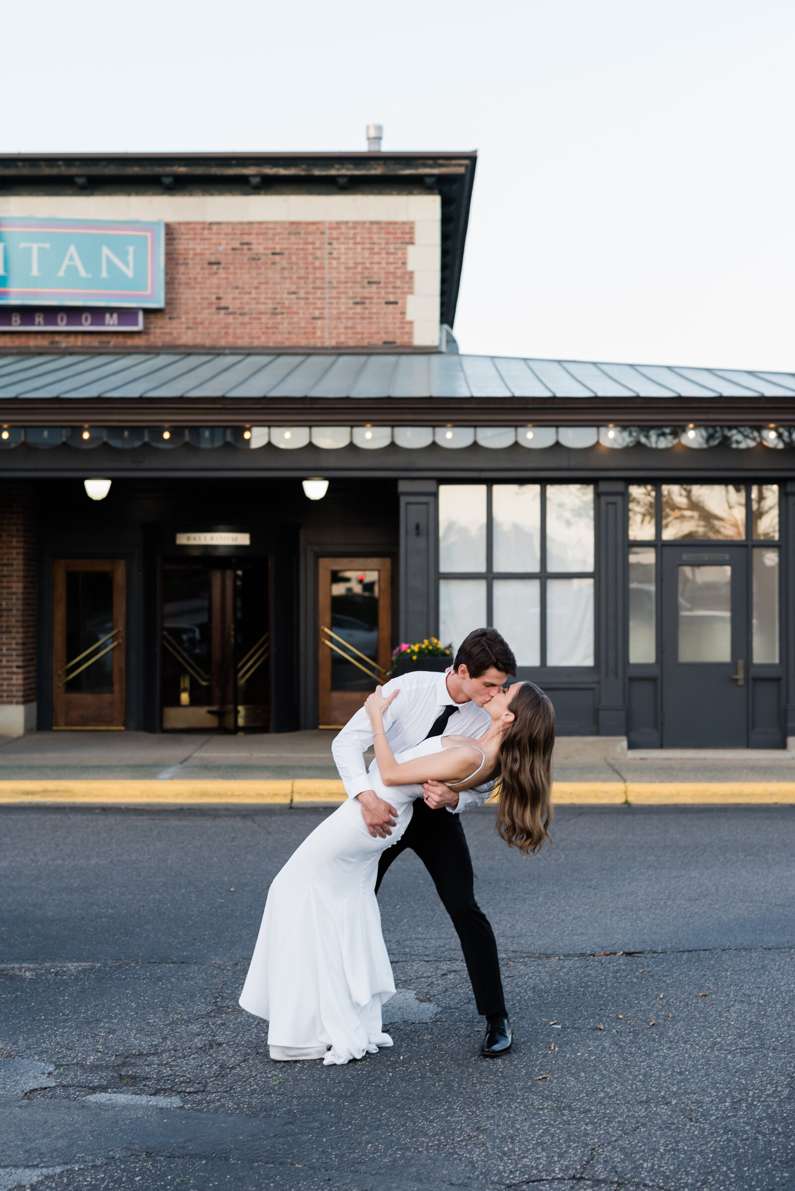 Wedding couple doing a dip kiss in front of the Metropolitan Ballroom