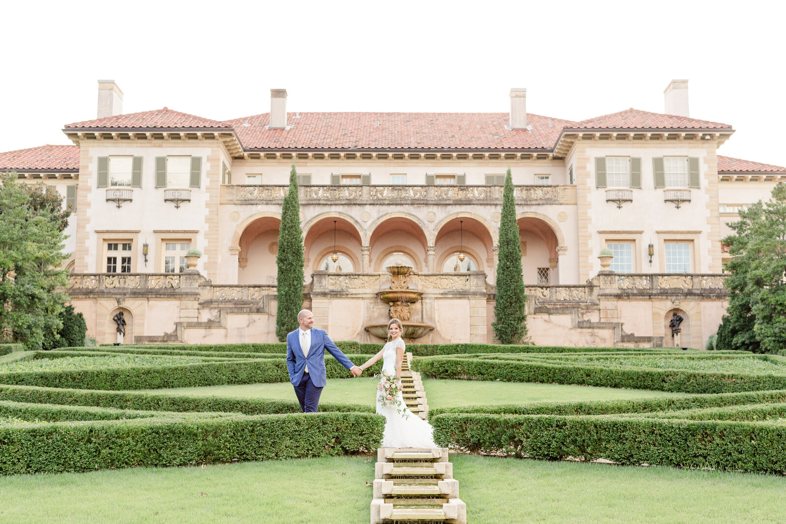 Bride and groom walking through The Philbrook Museum's lush, Tuscan style  garden in Tulsa, Oklahoma on their wedding day.