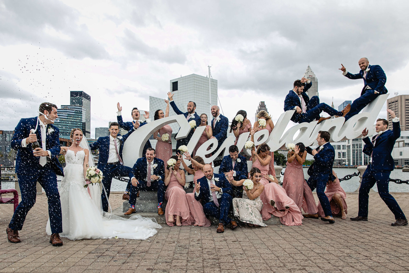 bridal party with champaign at Cleveland sign