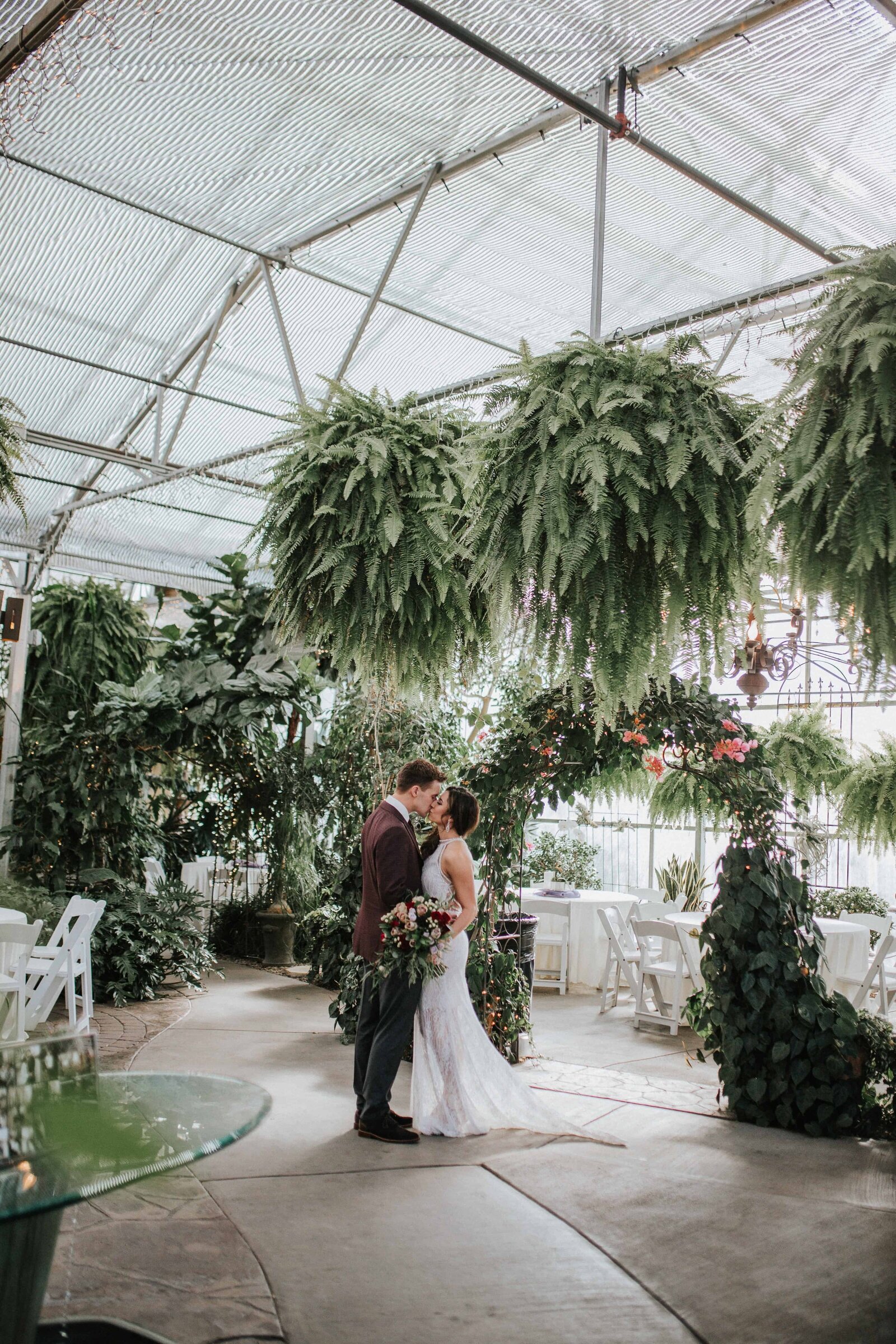 bride and groom kissing next to greenery in Knoxville Tennessee