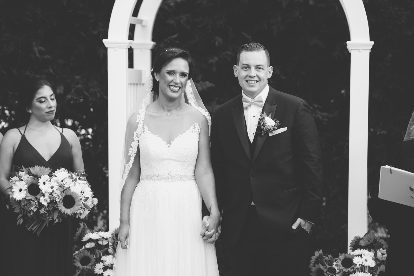 black and white photo of bride and groom walking down the aisle after ceremony  from Three Village Inn wedding