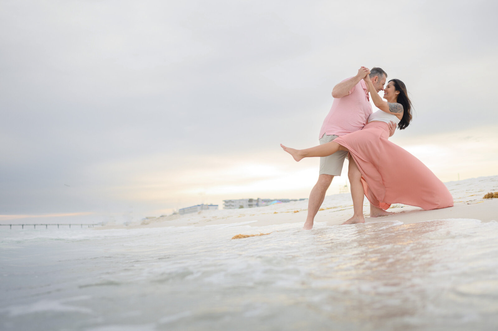 Engaged couple dancing with each other at the beach