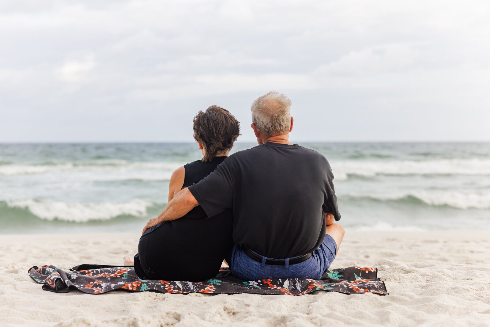Grandparents sitting on Pensacola Beach looking out at water - Jennifer Beal Photography