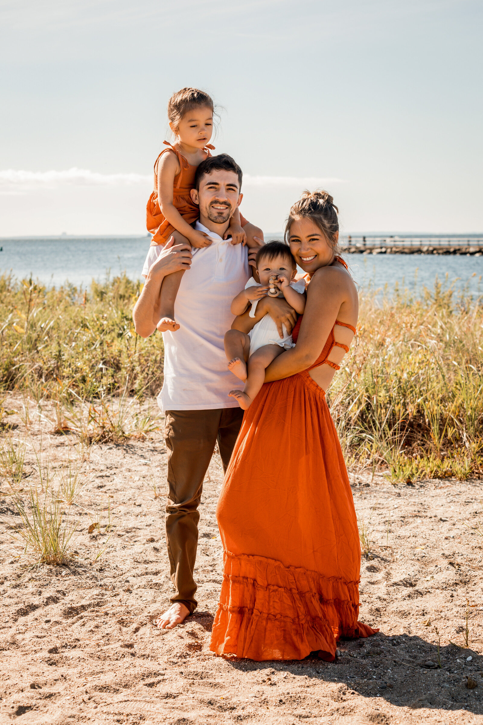 family smiling on the bridgeport beach