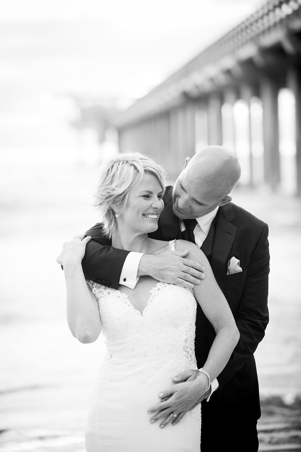 black and white bride and groom with pier