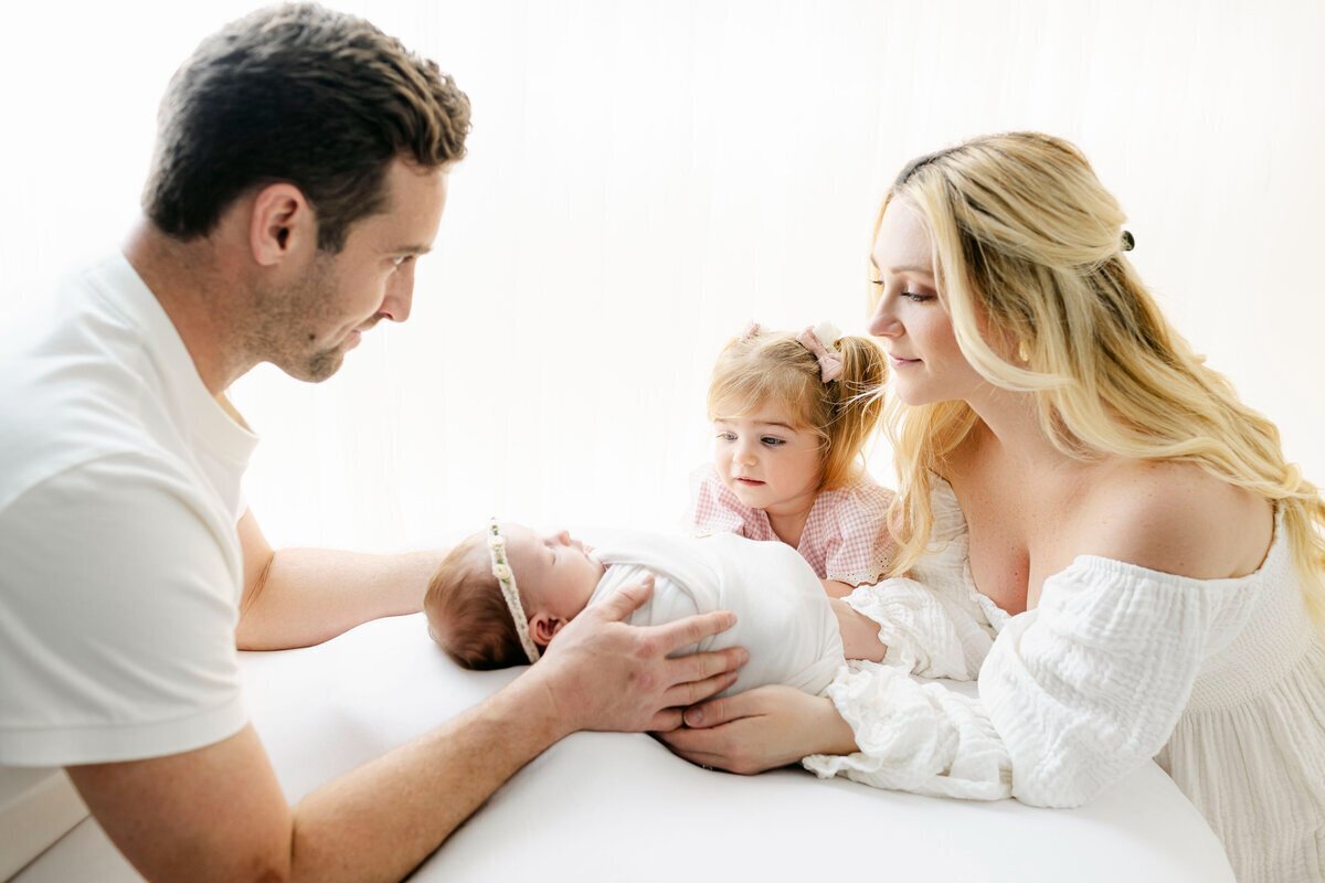 Parents and little girl looking at newborn baby, taken by nj newborn photographer