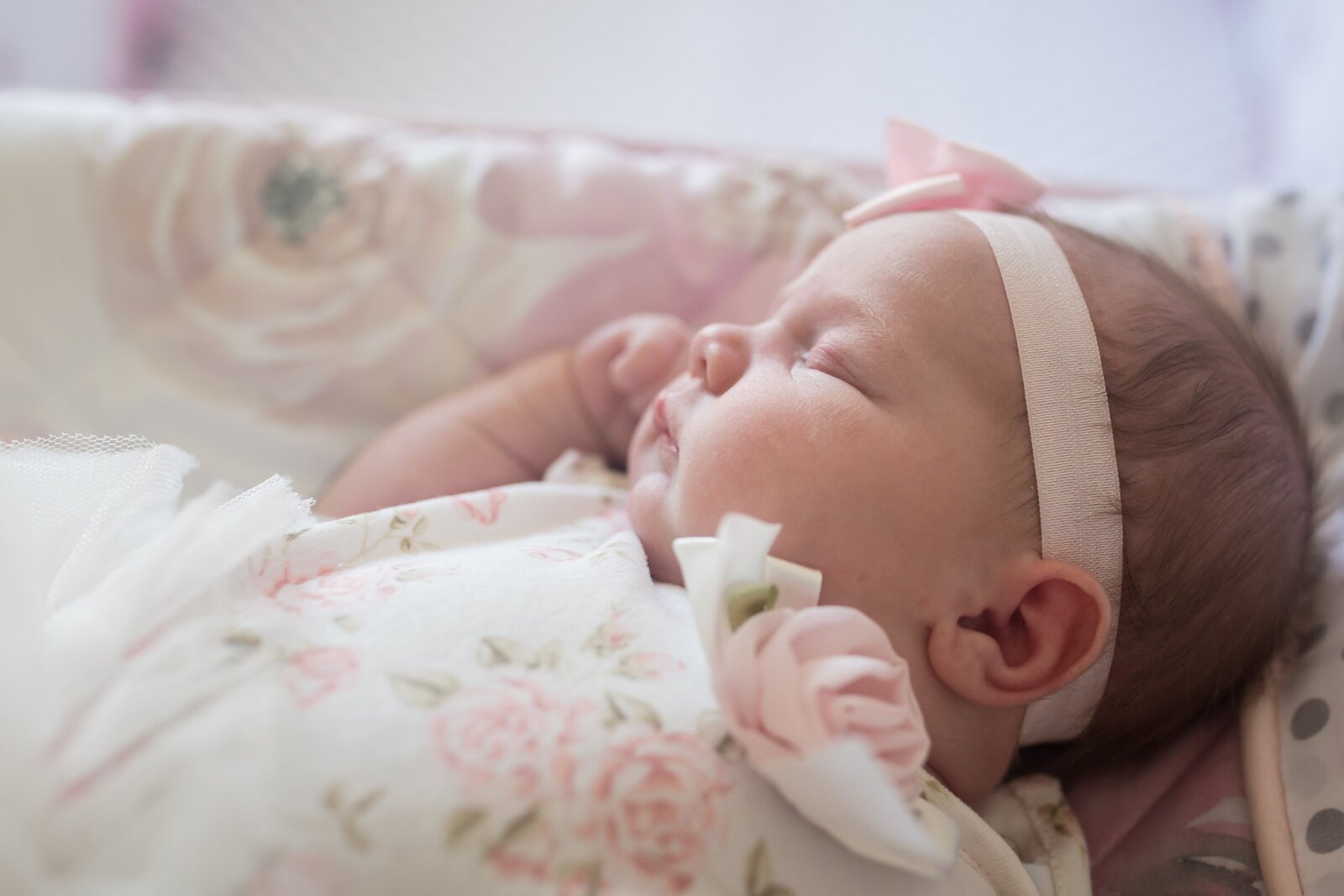 Newborn girl asleep in nursery during in home photo session.