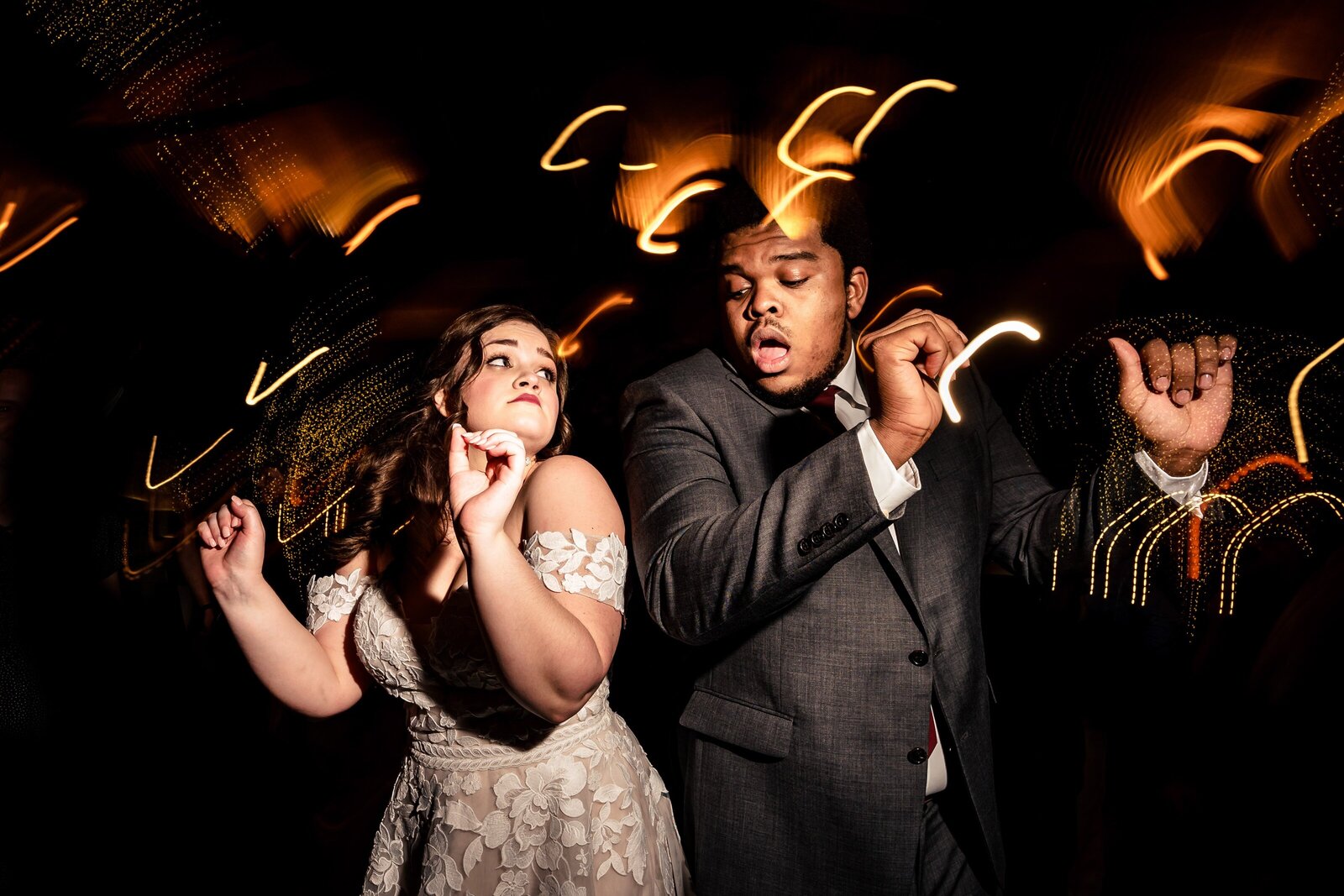 man in a suit and woman in a wedding dress dance at a wedding reception at The Angus Barn