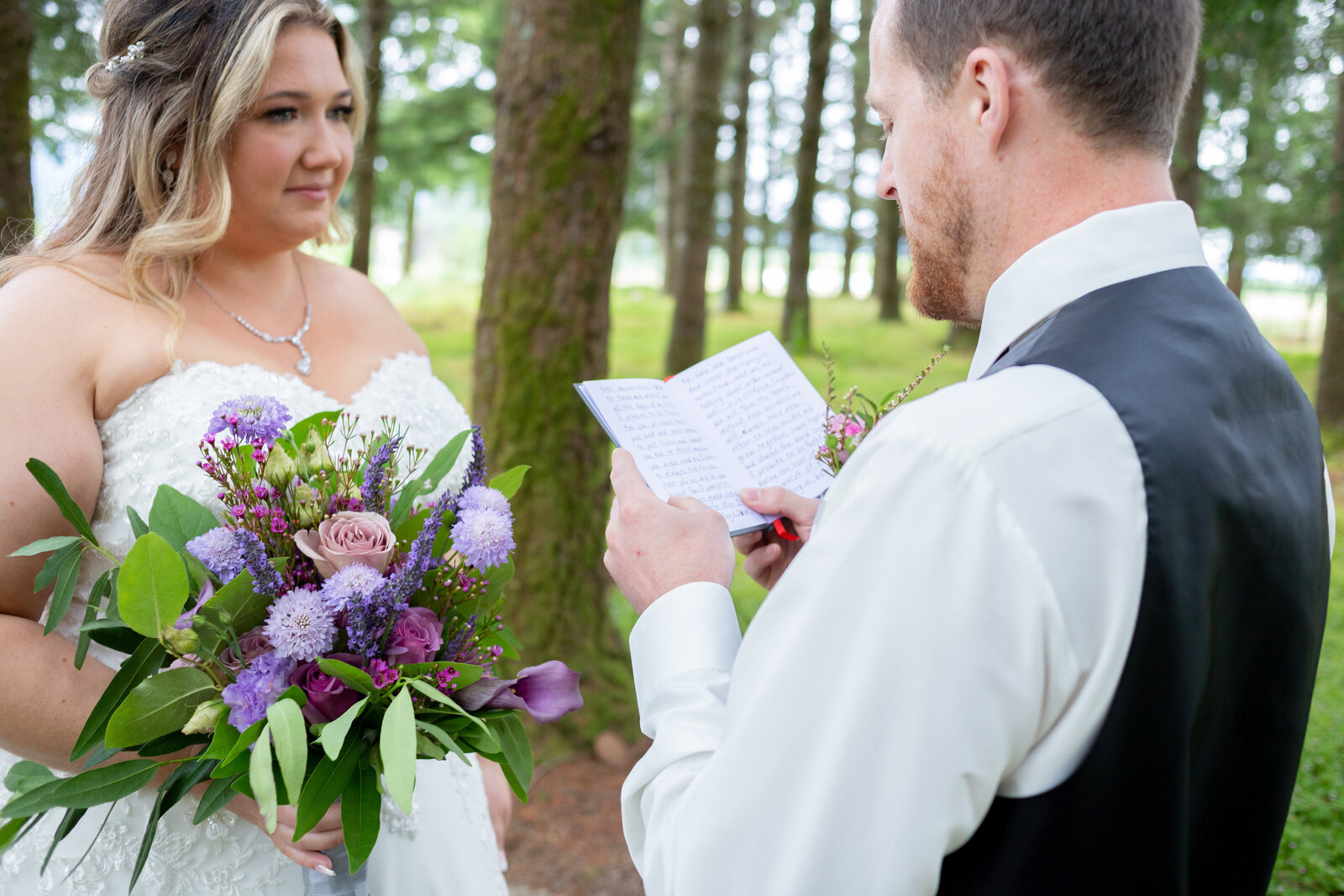 Seattle Wedding Photographers capture groom reading vows to bride holding bouquet