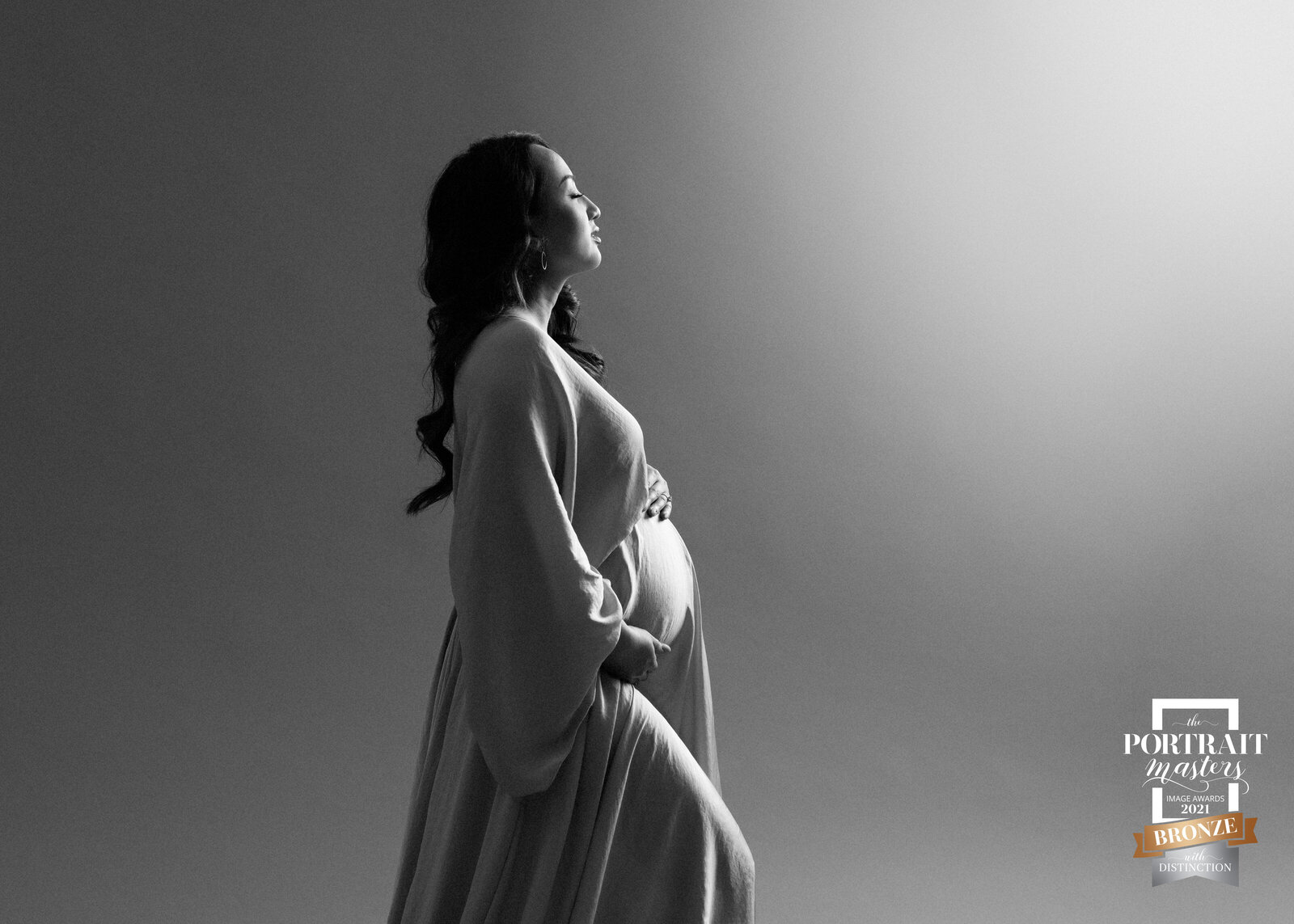 black and white bare belly maternity portrait with light flare