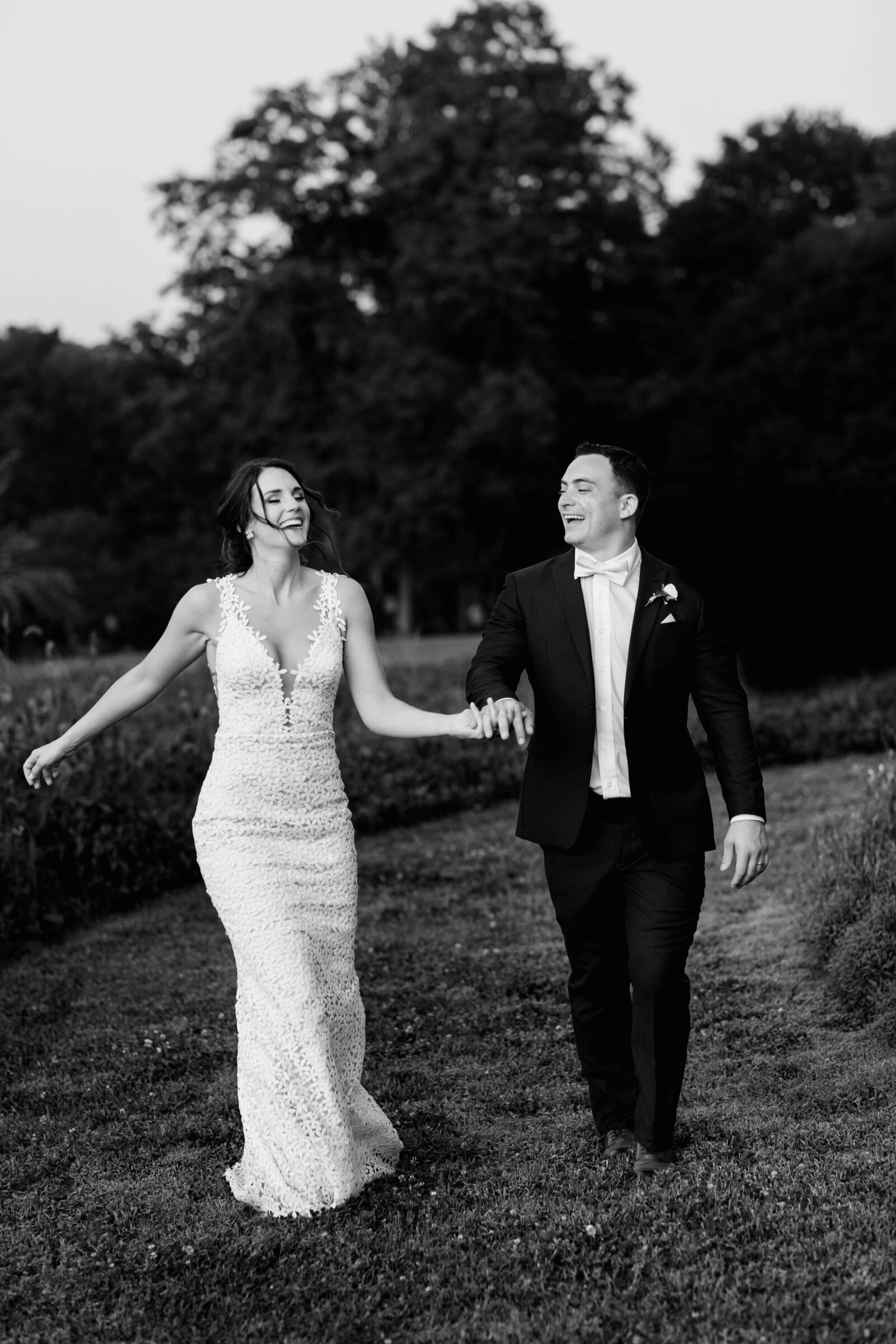 bride and groom laughing walking in field