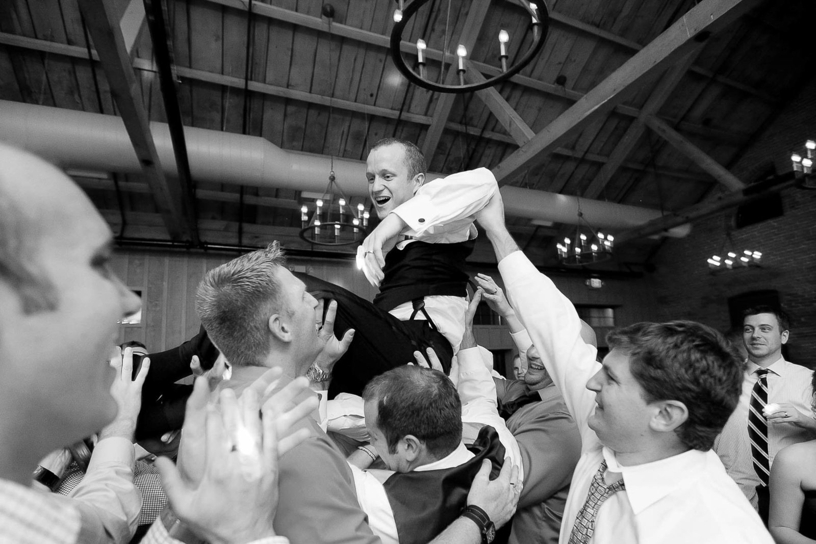 Groom is lifted by guests at reception, Cork Factory Hotel, Lancaster, Pennsylvania