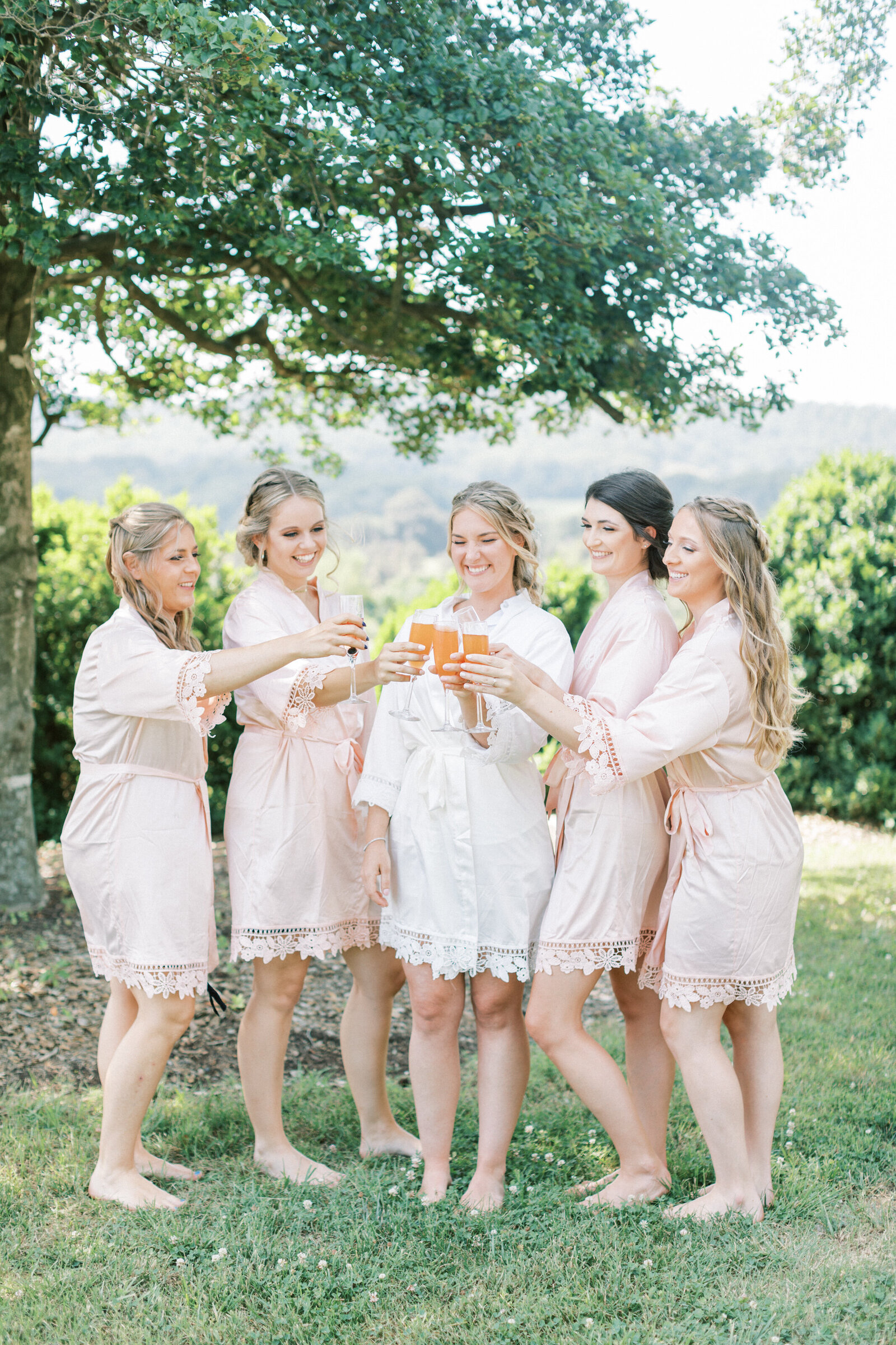 Bridesmaids all toast to the bride in their robes