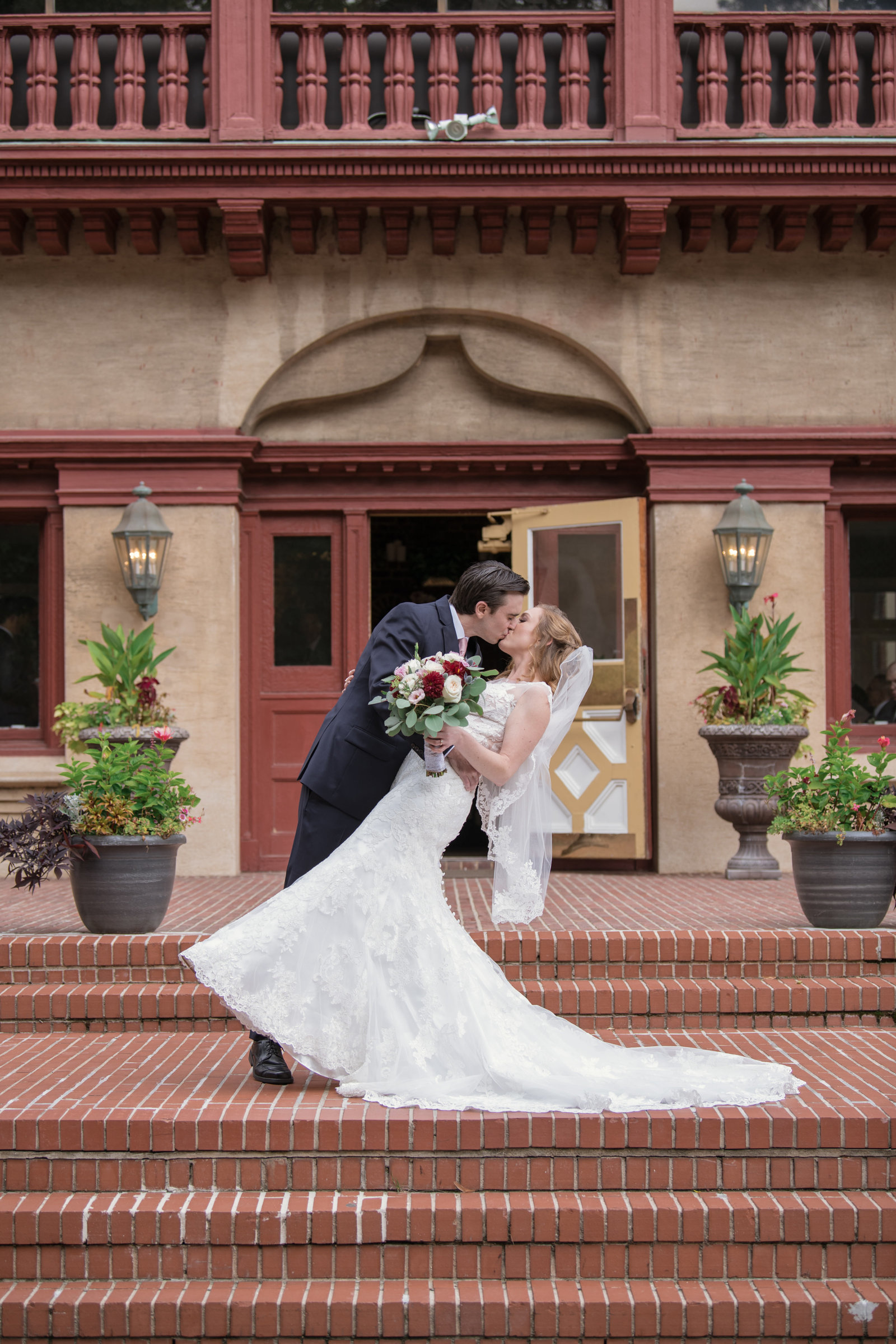 bride and groom kissing photo in front of Coindre Hall