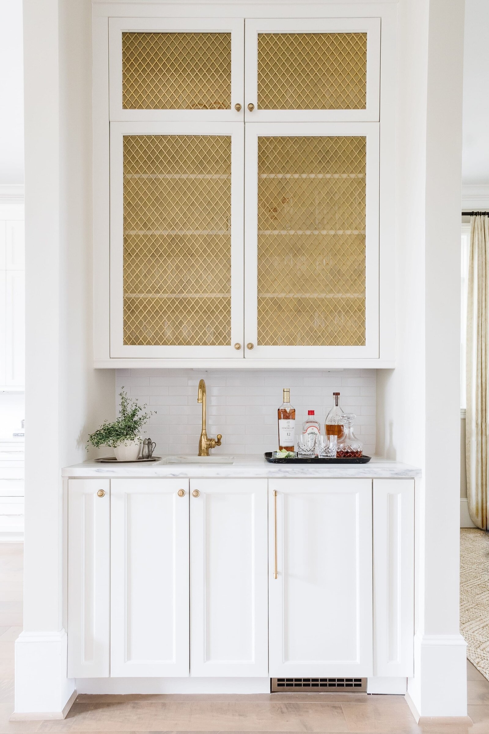vision and hammer bar nook with gold faucet and white cabinets