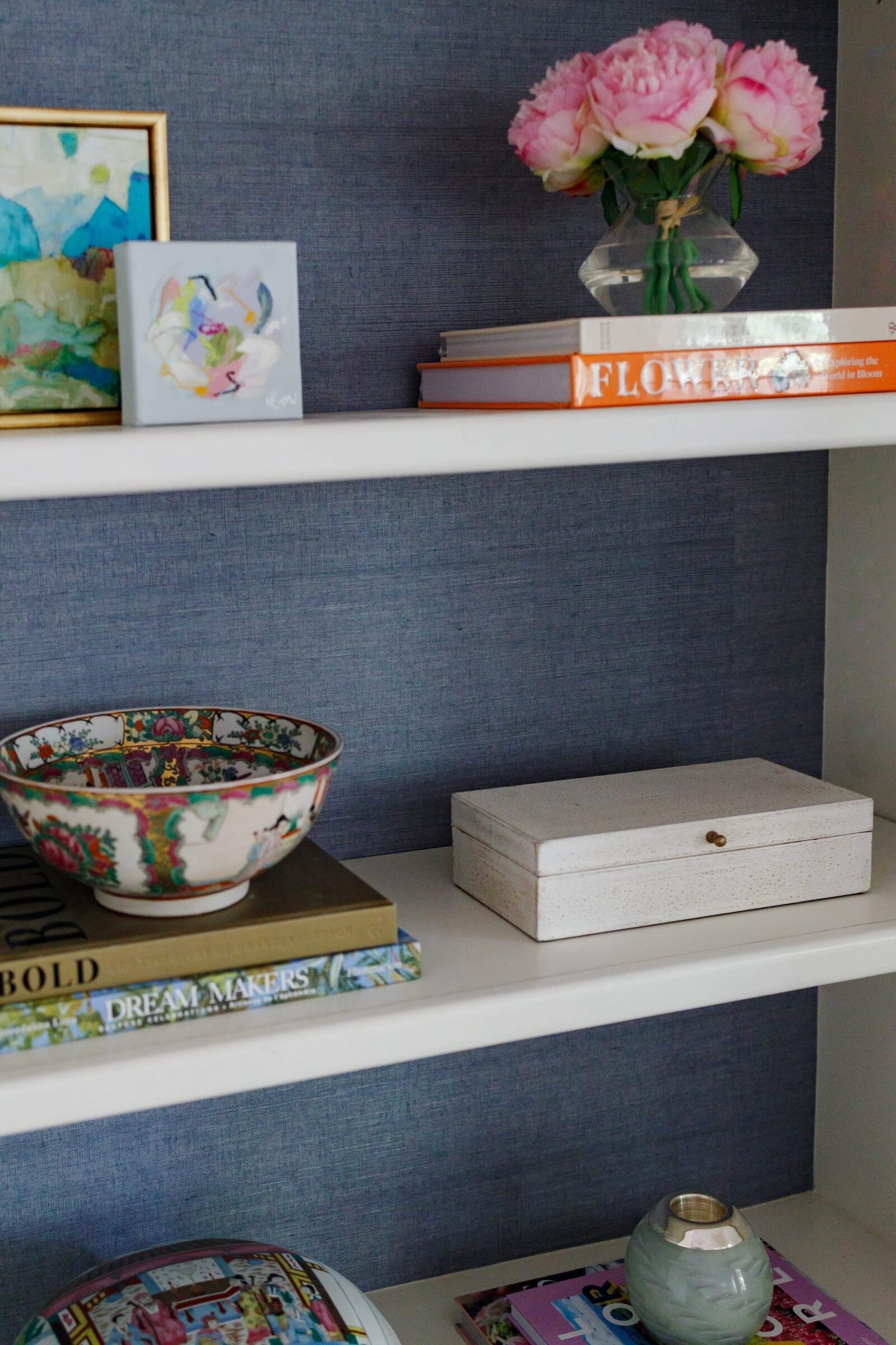 vision and hammer styling shelf decorated with books and pink flowers 