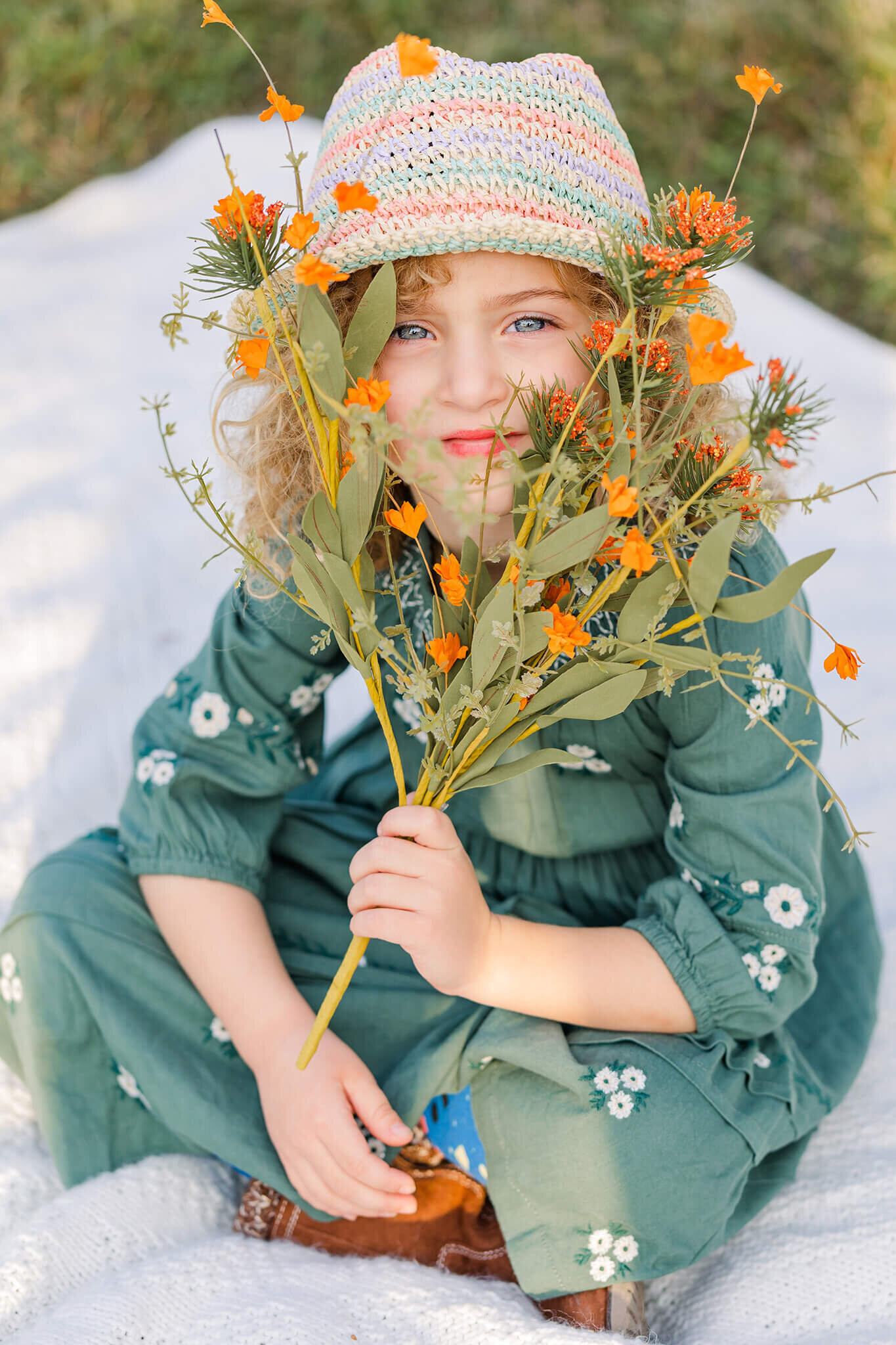 A little girl holding a bouquet of flowers in front of her face during a Northern Virginia family photo session.