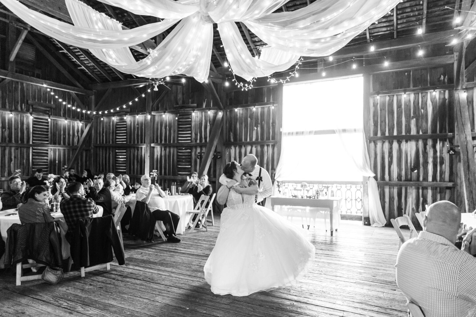 Bride and groom dance in the ohio barn. Photo is a black and white photo taken by dayton wedding photographer