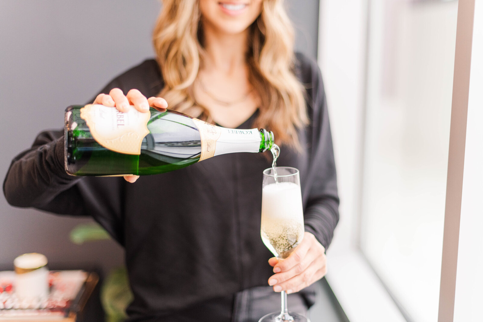 beautiful woman pouring champagne into glass