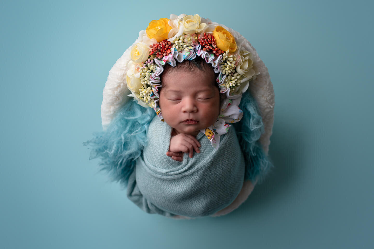 Newborn in a yellow flower bonnet