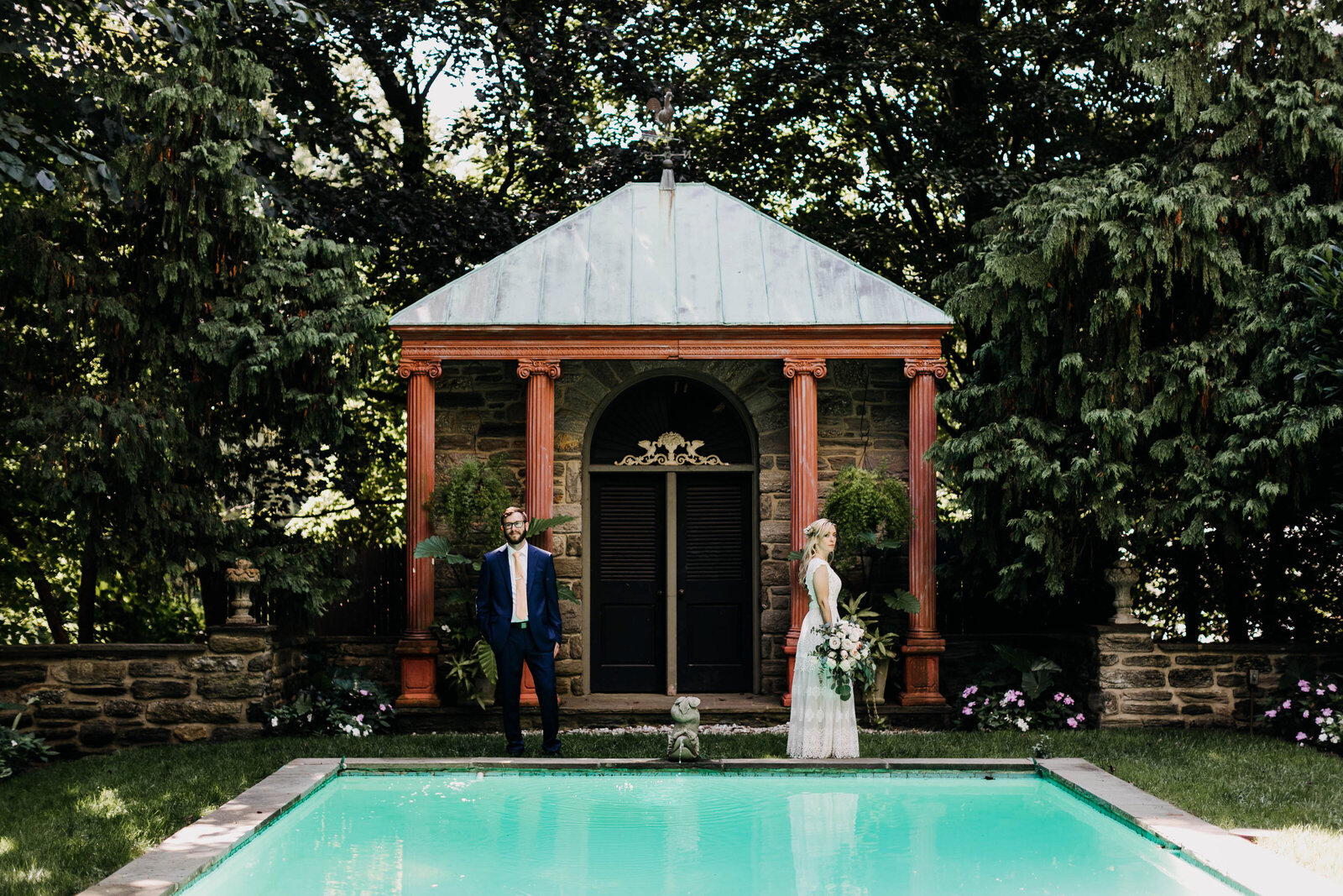 bride and groom in garden with pool