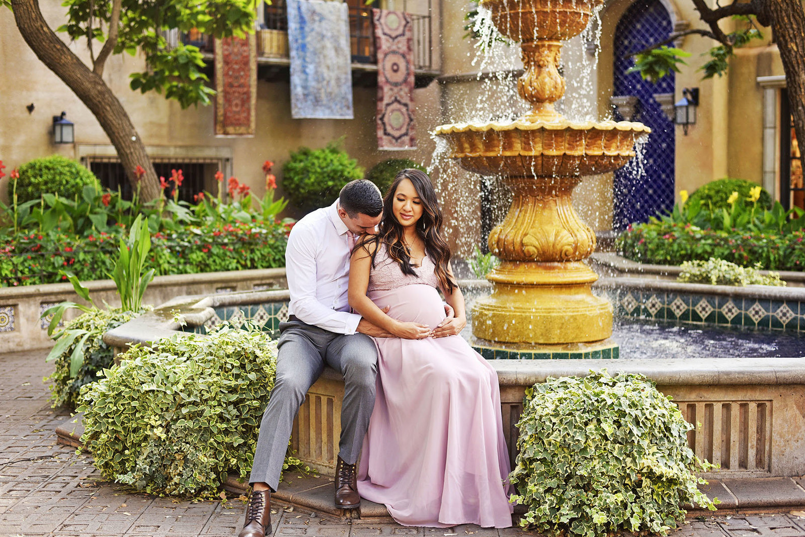 Tlaquepaque village Sedona maternity couple pregnant kissing shoulder sitting at fountain Sedona photography