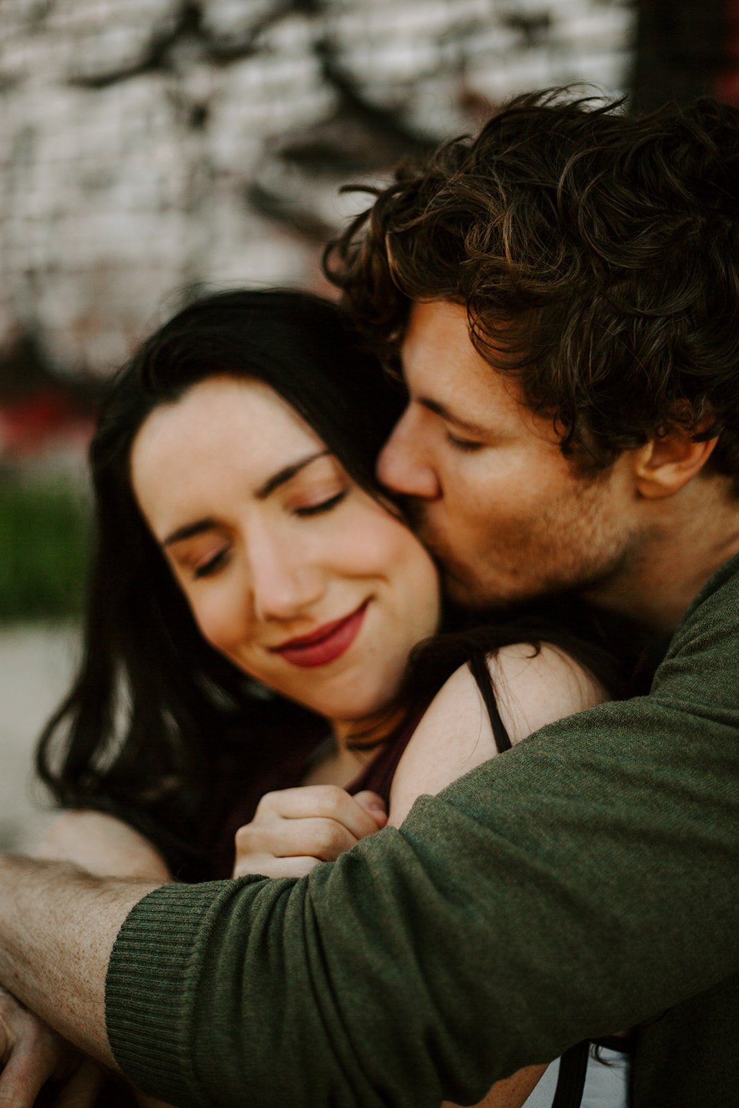 Man kissing his girlfriend on the cheek during his Minneapolis engagement session