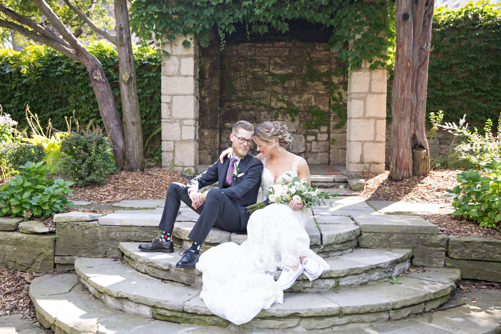 bride and groom sitting on stone steps at Whitehern Hamilton
