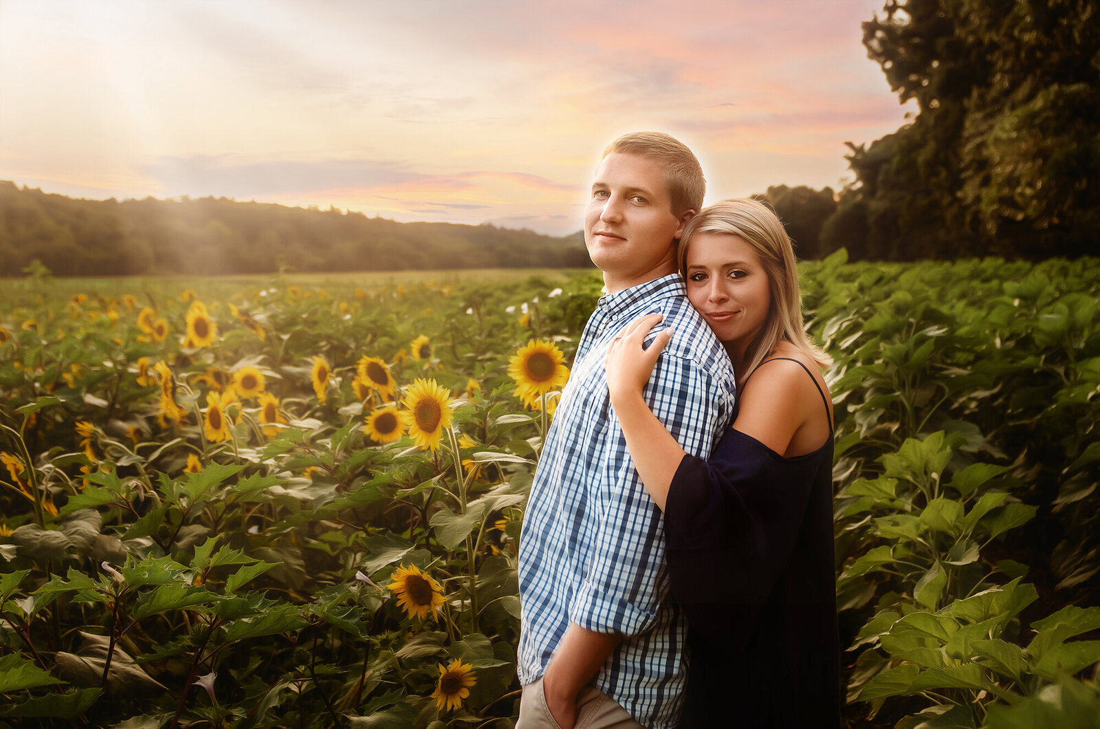 A couple poses for Engagement Photos in a sunflower field in Asheville, NC.
