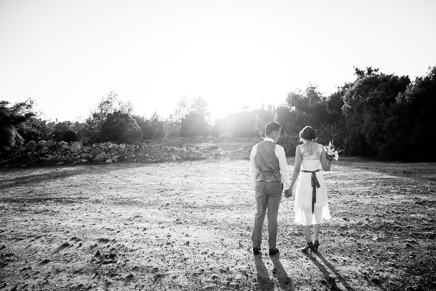Black and white wedding portrait composed with the sunset