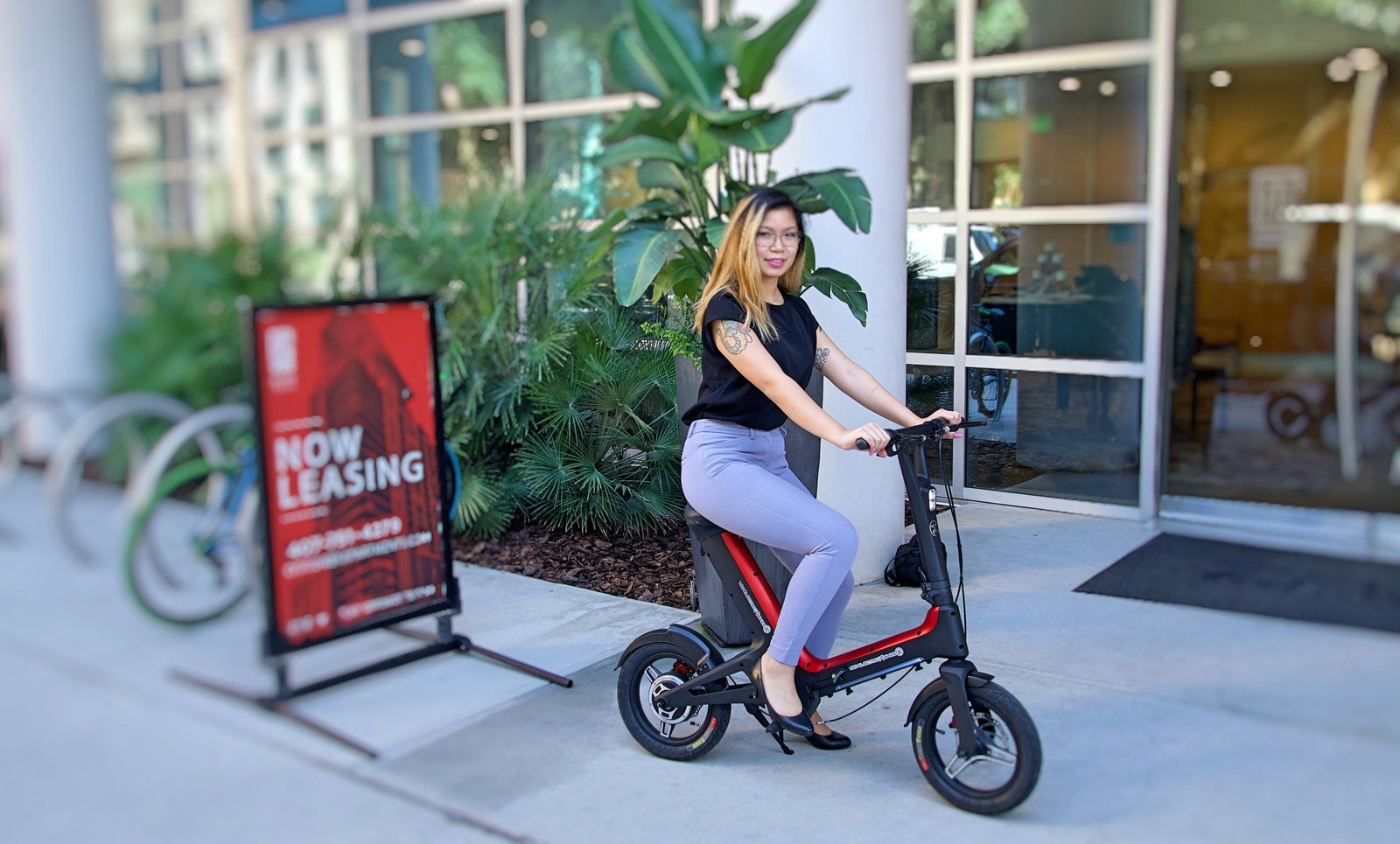 Lady on Red Go-Bike M3 in front of leasing office