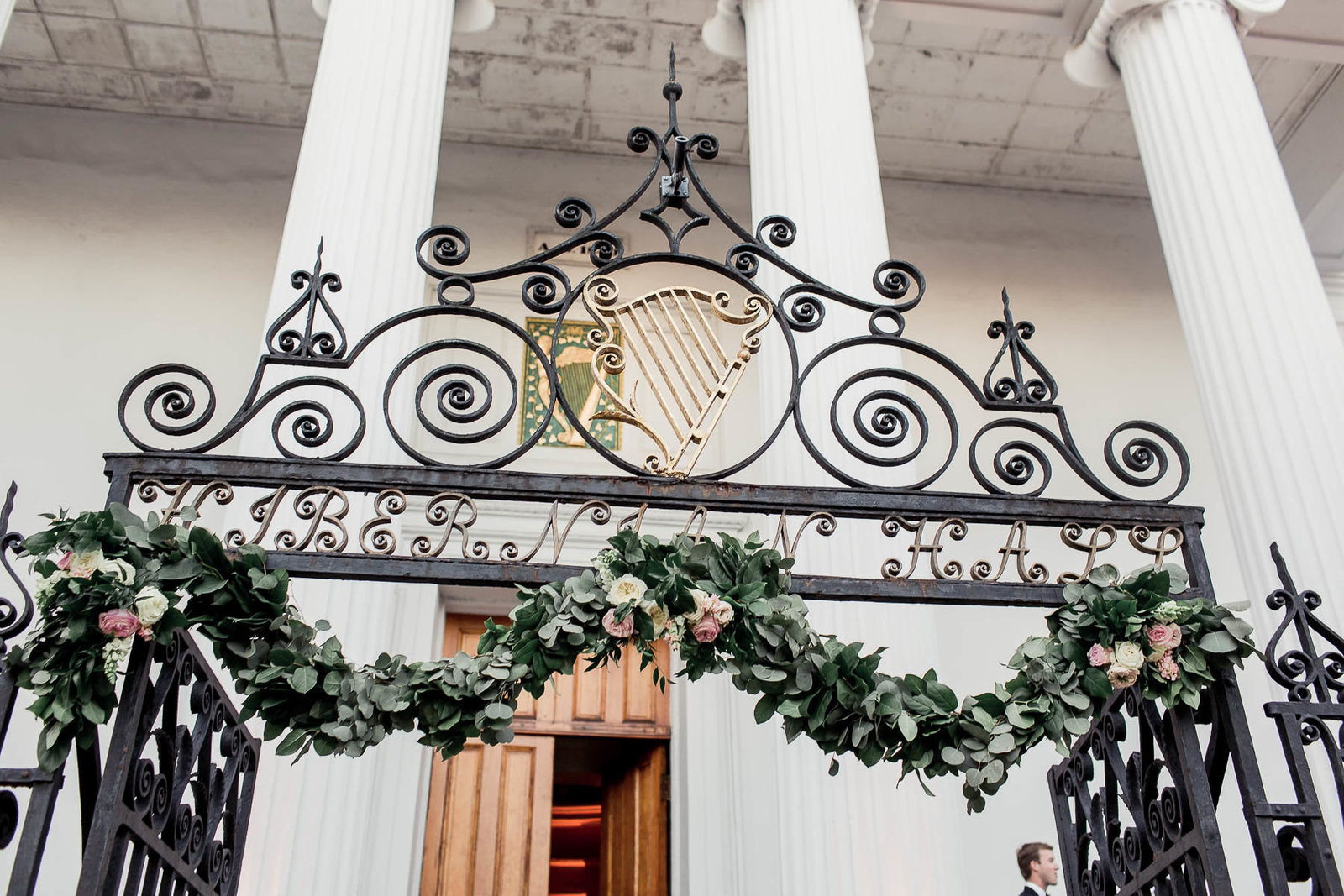 Garland is hung on ornate gate of Hibernian Hall, Charleston Wedding Photographer.