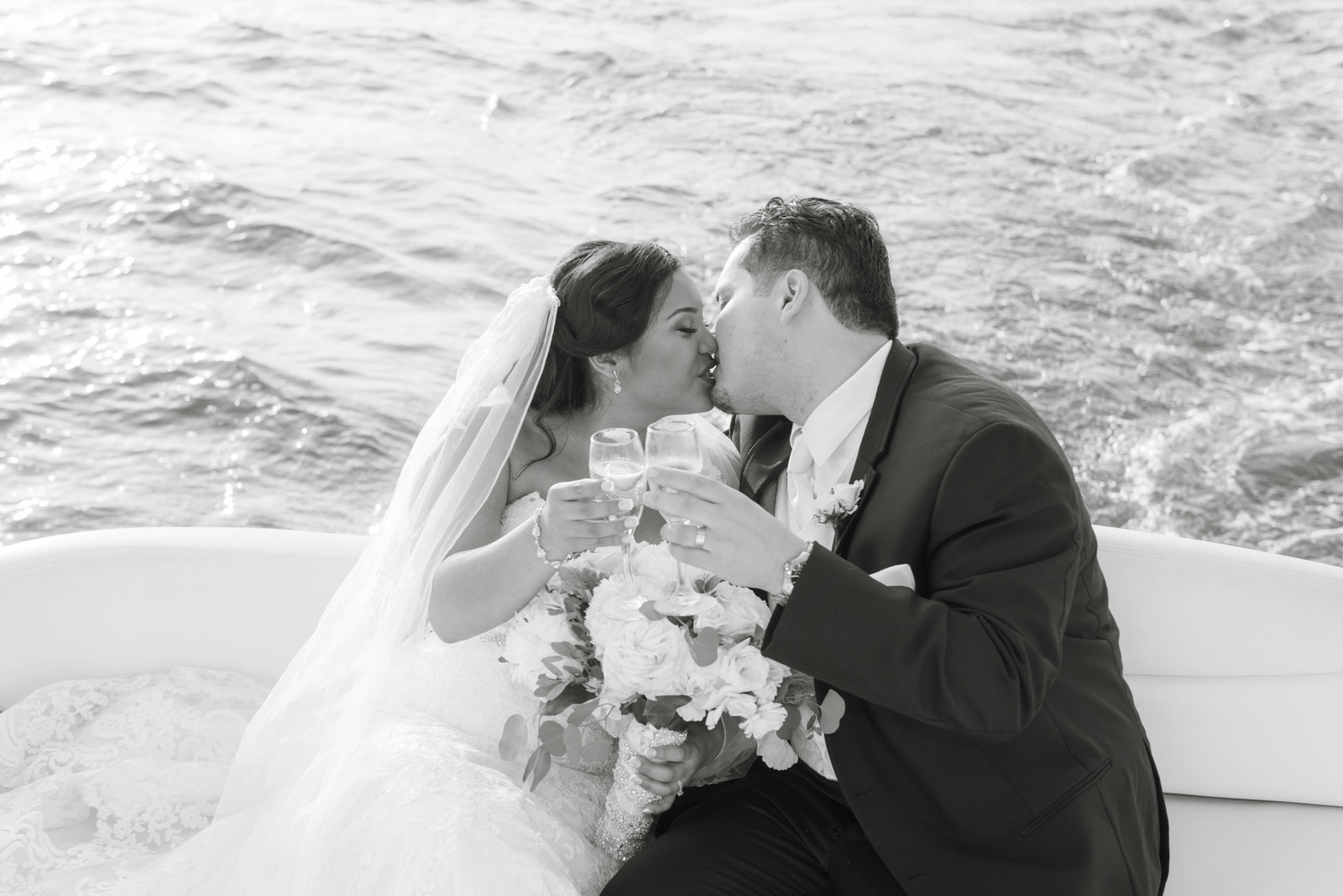 Bride and groom kissing on boat at Chateau La Mer