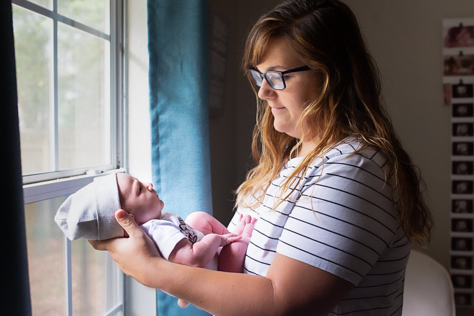 new mom looking at newborn son during newborn photo session.