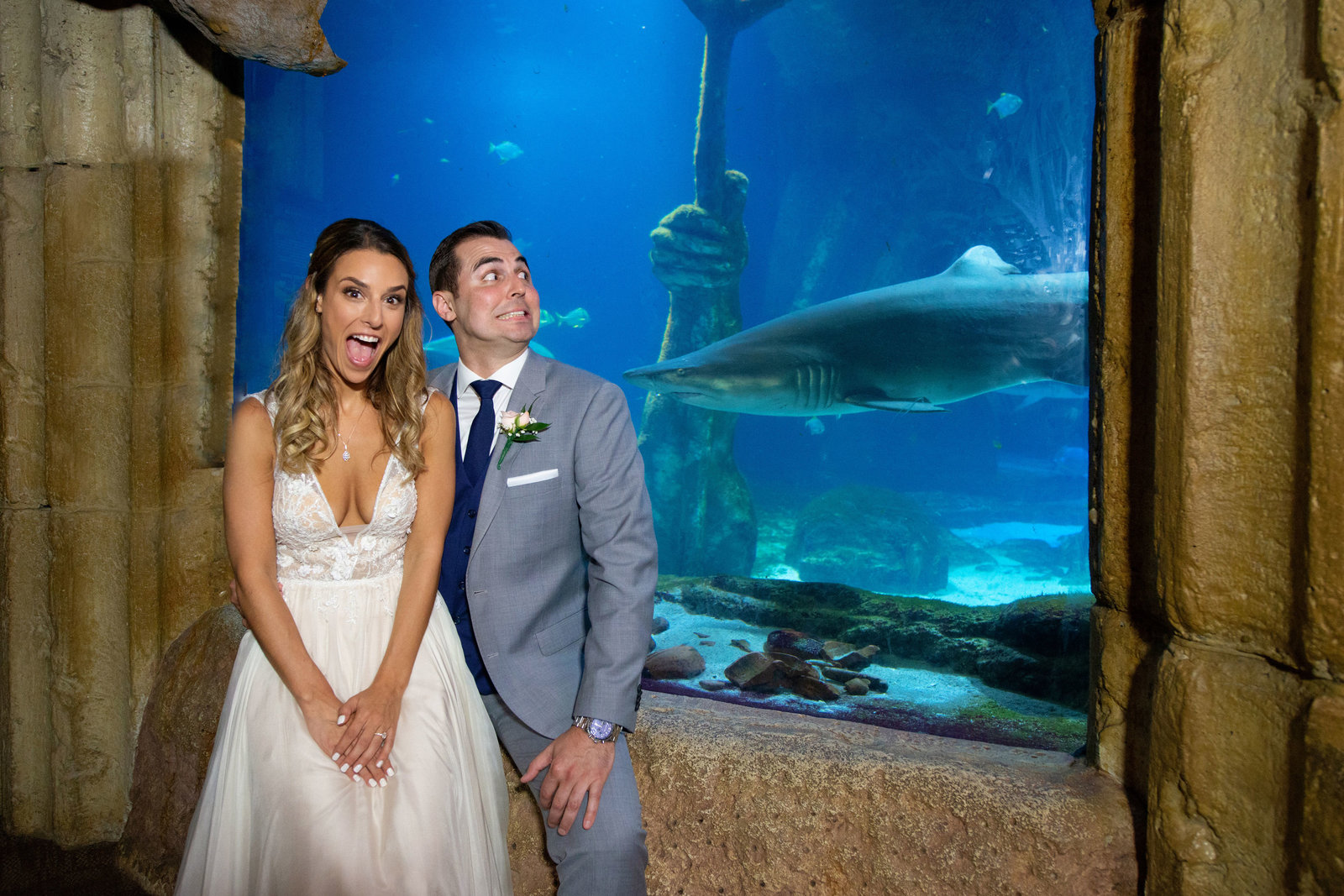Bride and groom in front of sharks at Atlantis Banquet and Events